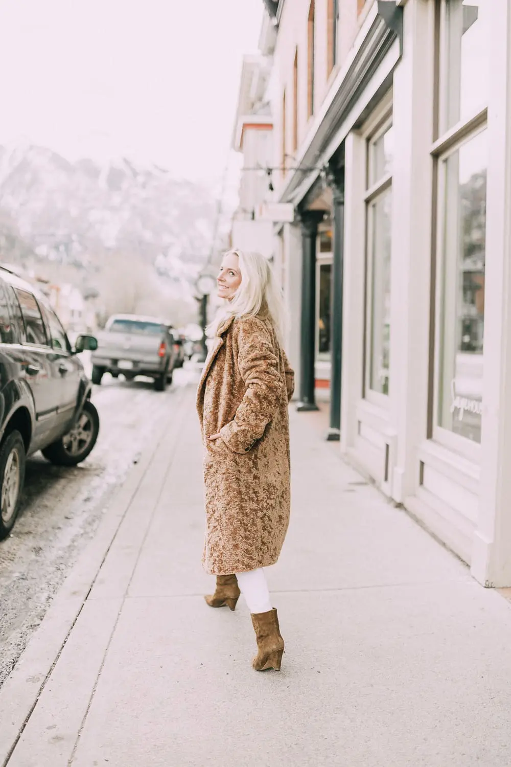 Fashion blogger Erin Busbee of BusbeeStyle.com wearing an all white look including white jeans and white blouse with an Avec Les Filles faux shearling cocoon coat