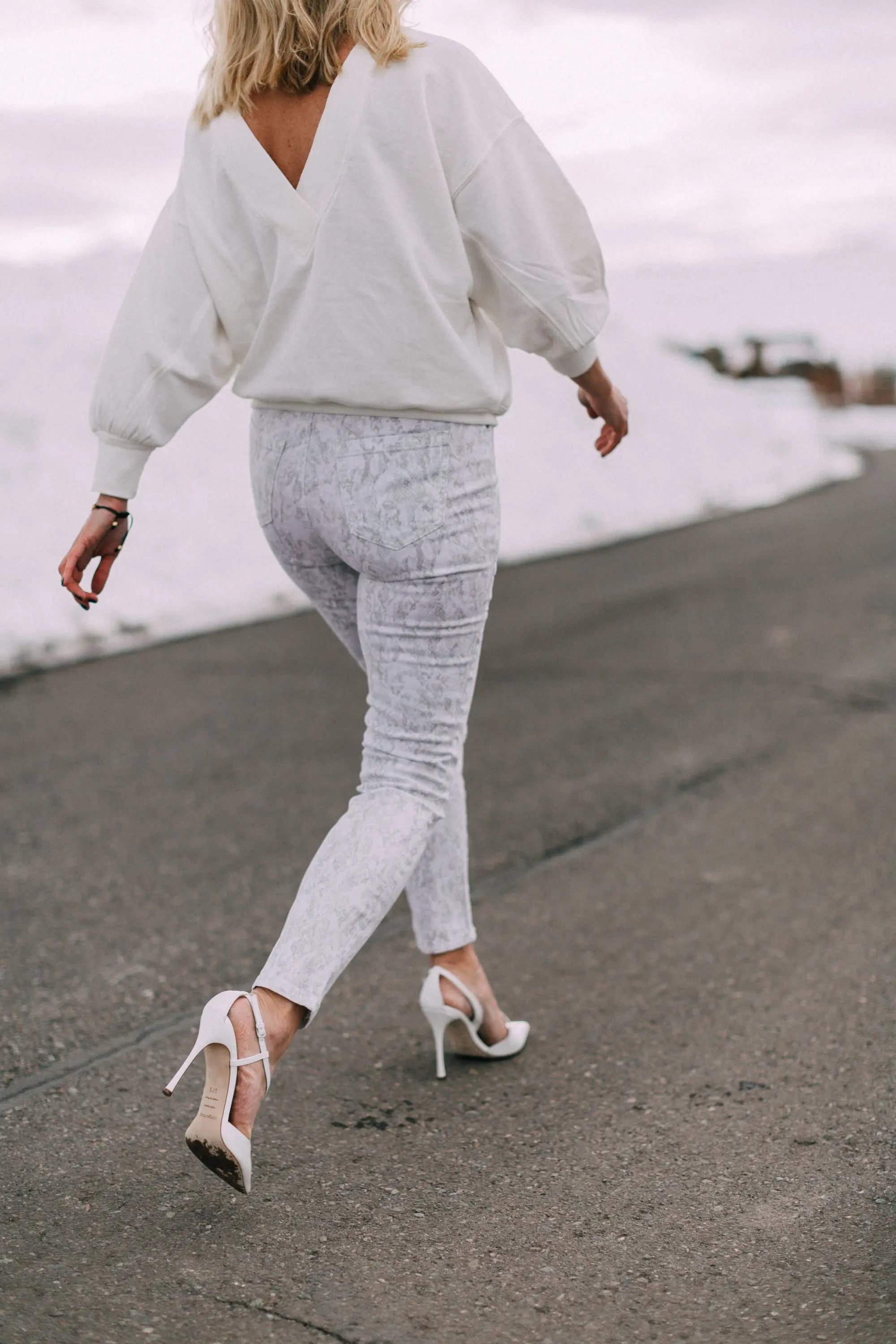 fashion blogger showing outfit with white snakeskin walmart sofia vergara jeans outfit with white pumps and open back sweatshirt