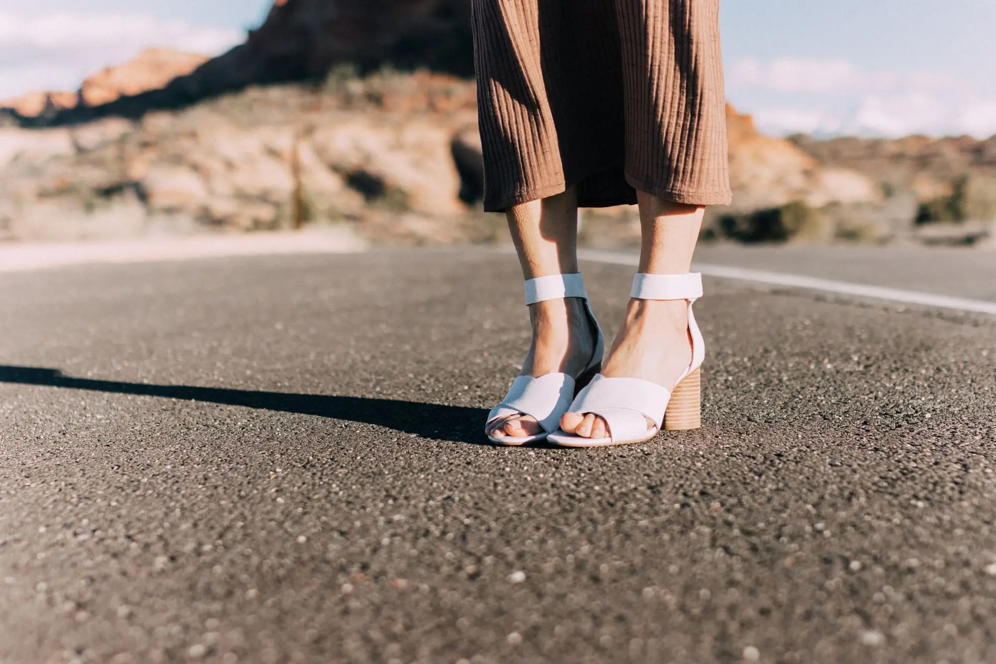 Spring Handbags, Fashion blogger Erin Busbee of BusbeeStyle.com wearing a long brown sweater dress by David Lerner from Revolve and white ankle strap sandals from Vince Camuto in Moab, Utah