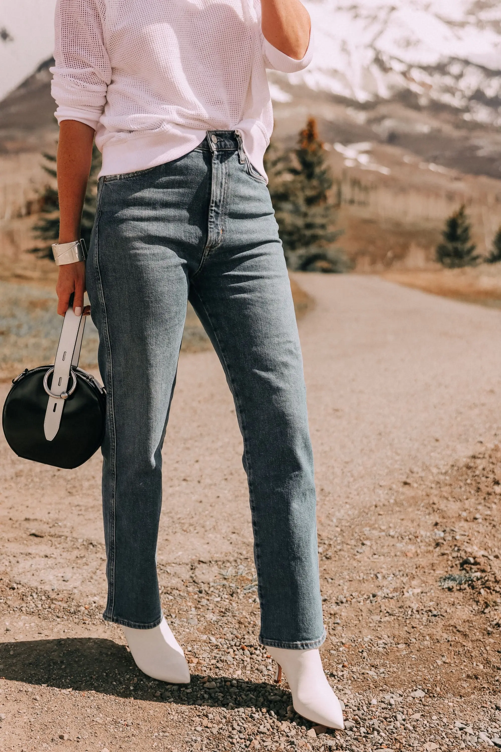 Lightweight Sweater For Summer, Fashion blogger Erin Busbee of BusbeeStyle.com wearing a white sweater by Eileen Fisher, with AGOLDE jeans, white Stuart Weitzman booties, and a black and white Rebecca Minkoff bag from Bloomingdale's in Telluride, CO
