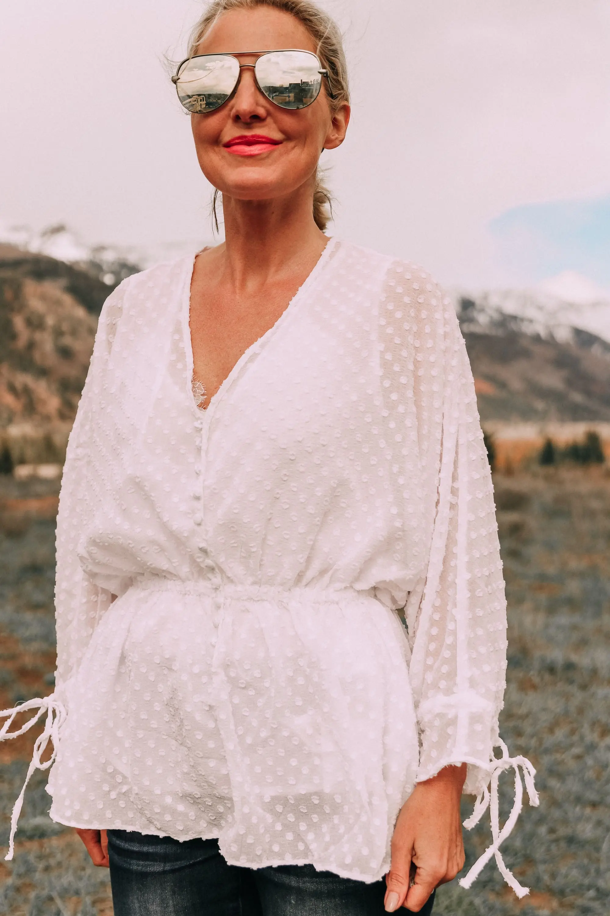 fashion blogger erin busbee wearing white cinched blouse styled with mirrored aviator sunglasses