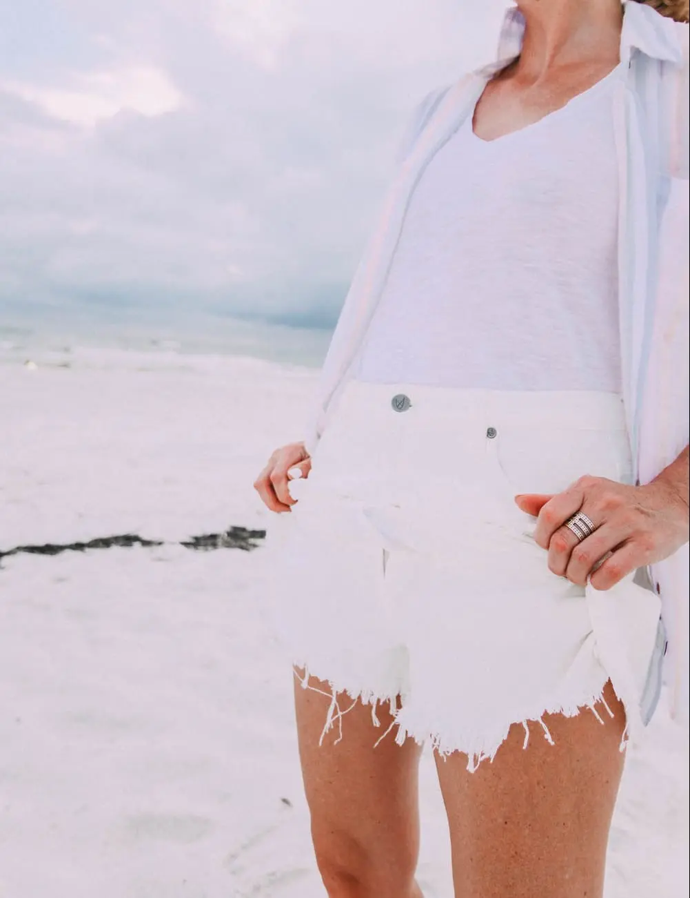 Skorts, Fashion blogger Erin Busbee of BusbeeStyle.com wearing a white denim skort fro Revolve with a Madewell tee and Rails striped button down on the beach in Florida