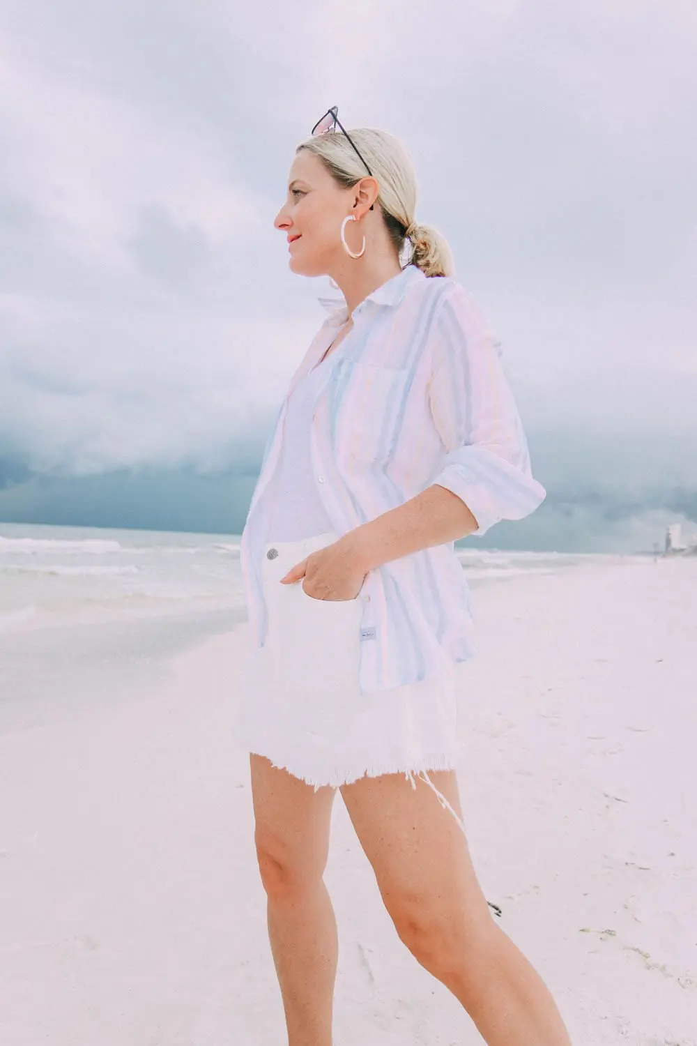 Skorts, Fashion blogger Erin Busbee of BusbeeStyle.com wearing a white denim skort fro Revolve with a Madewell tee and Rails striped button down on the beach in Florida