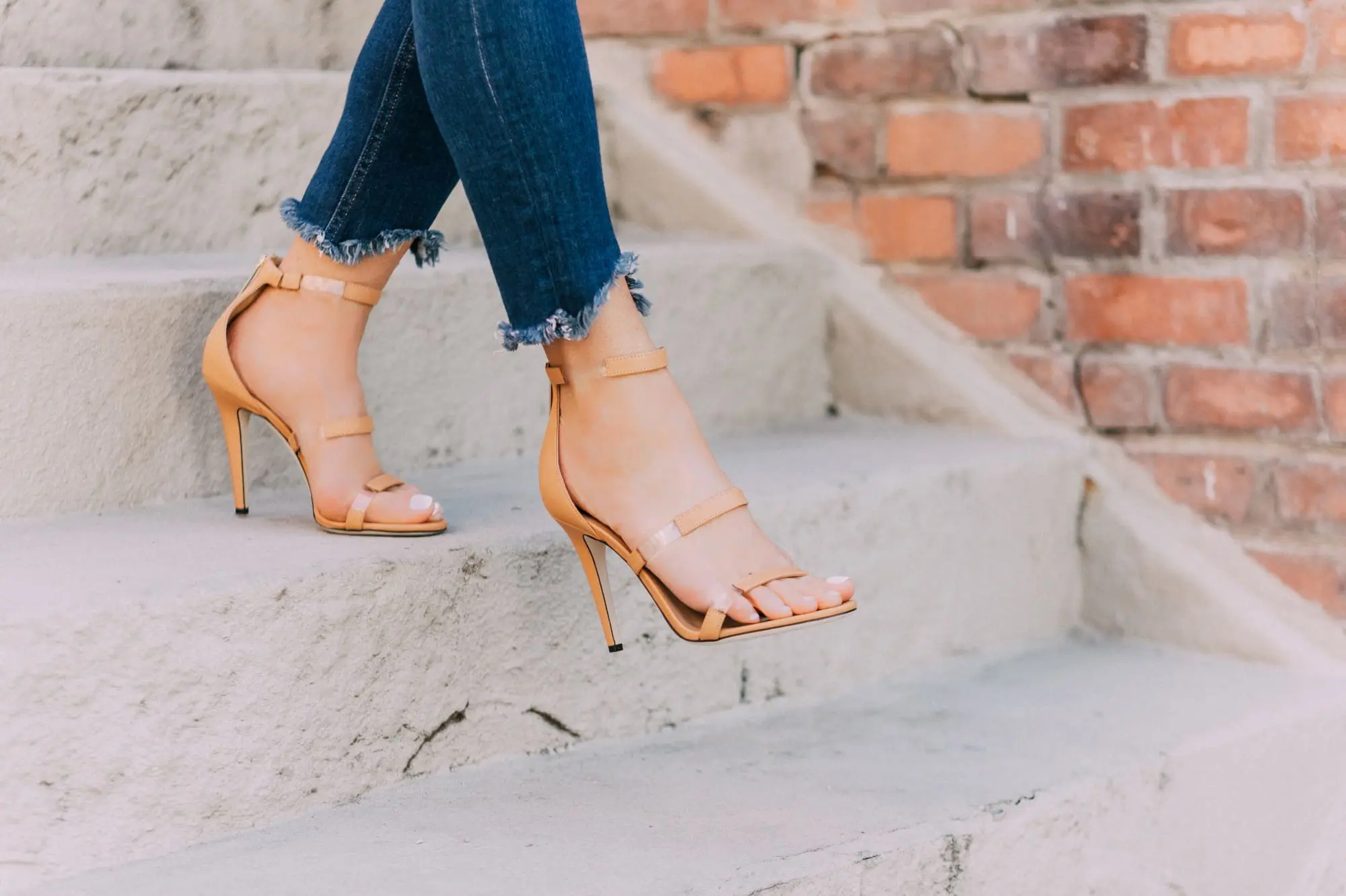 Tamara Mellon, Fashion blogger Erin Busbee of BusbeeStyle.com wearing dark was skinny jeans and white top with stunning Tamara Mellon Frontline heels in Telluride, Colorado