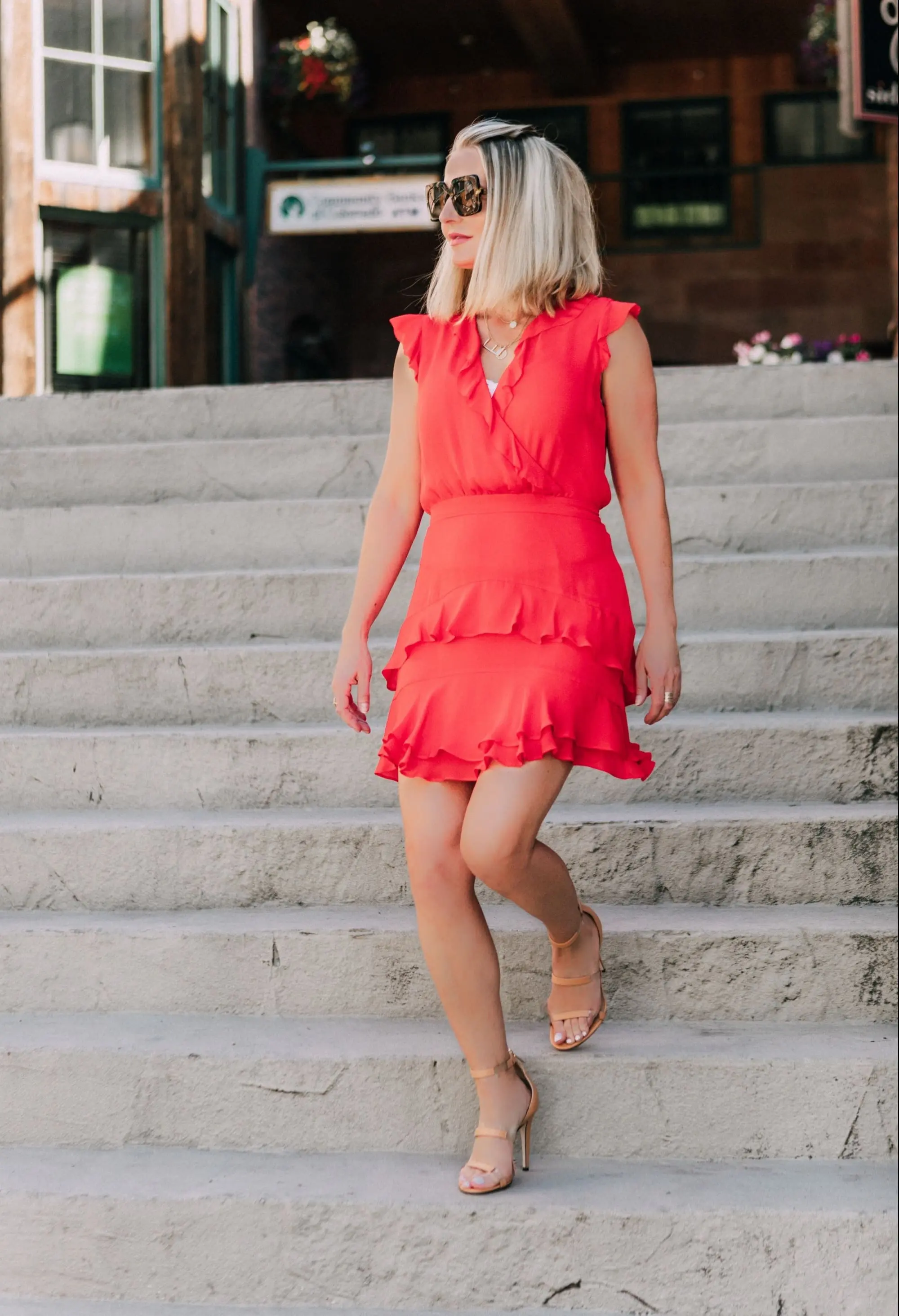 Tamara Mellon, Fashion blogger Erin Busbee of BusbeeStyle.com wearing a red ruffle dress with stunning Tamara Mellon Frontline heels in Telluride, Colorado