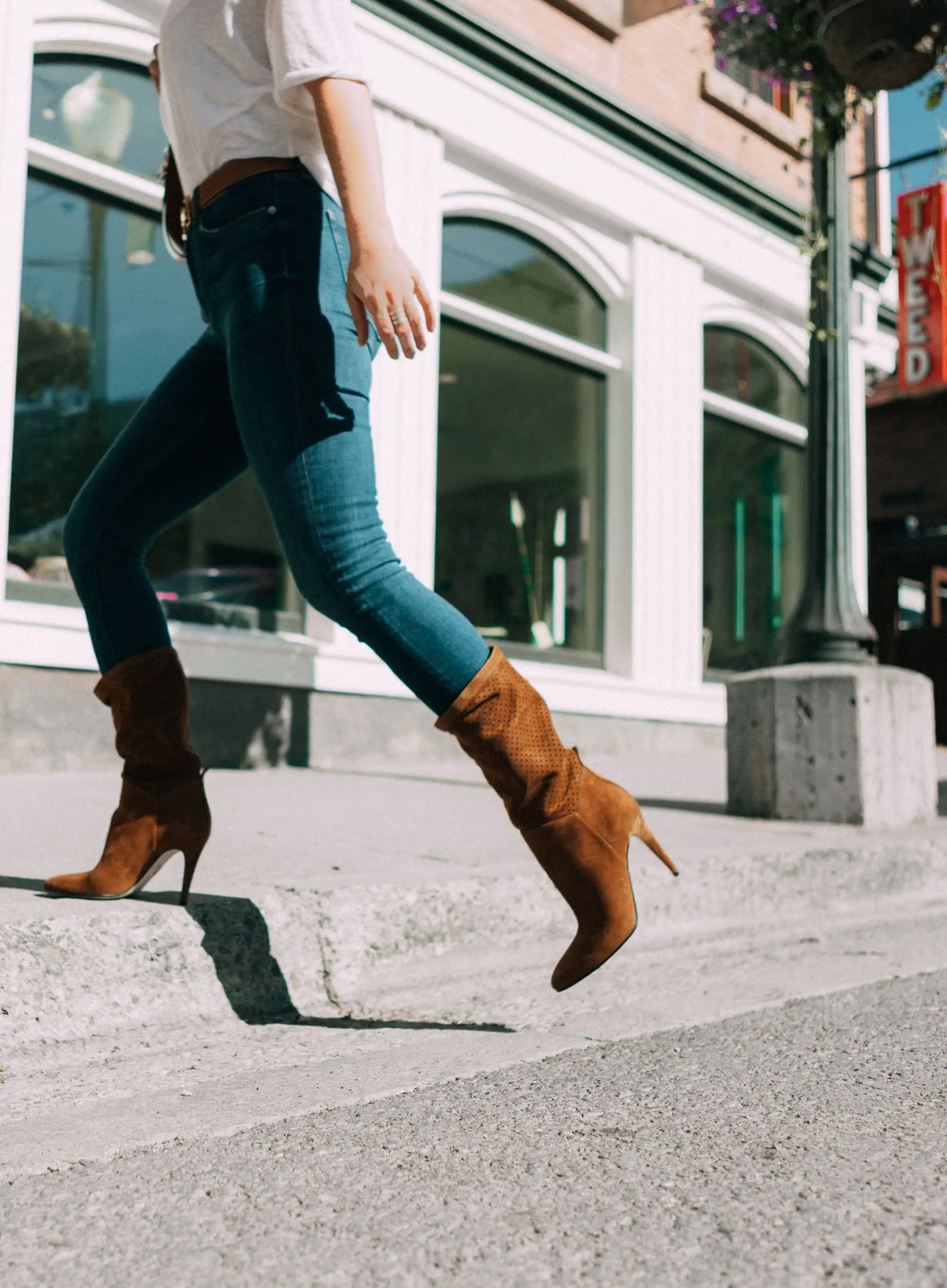 Tamara Mellon, Fashion blogger Erin Busbee of BusbeeStyle.com wearing dark was skinny jeans and white top with stunning Tamara Mellon Frontline heels in Telluride, Colorado