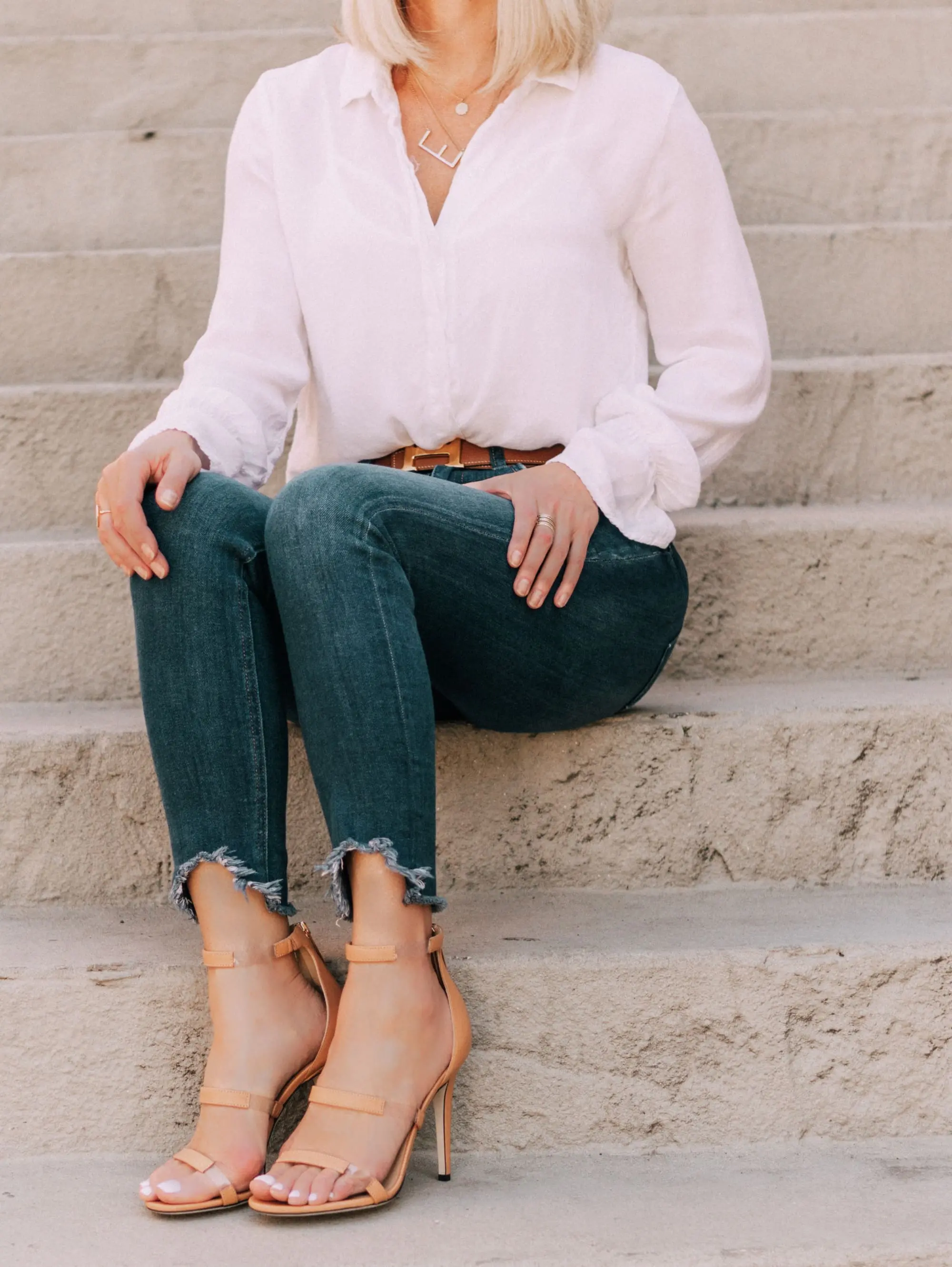 Tamara Mellon, Fashion blogger Erin Busbee of BusbeeStyle.com wearing dark was skinny jeans and white top with stunning Tamara Mellon Frontline heels in Telluride, Colorado