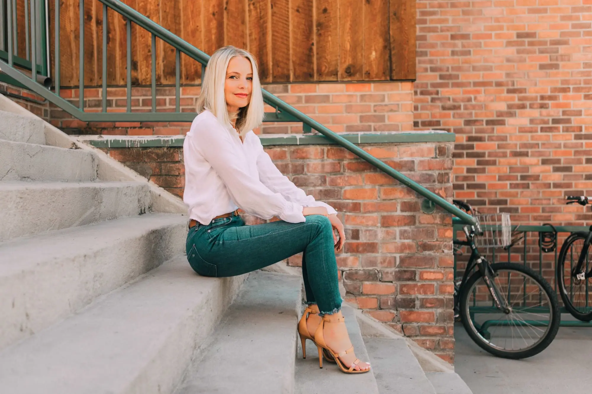 Tamara Mellon, Fashion blogger Erin Busbee of BusbeeStyle.com wearing dark was skinny jeans and white top with stunning Tamara Mellon Frontline heels in Telluride, Colorado
