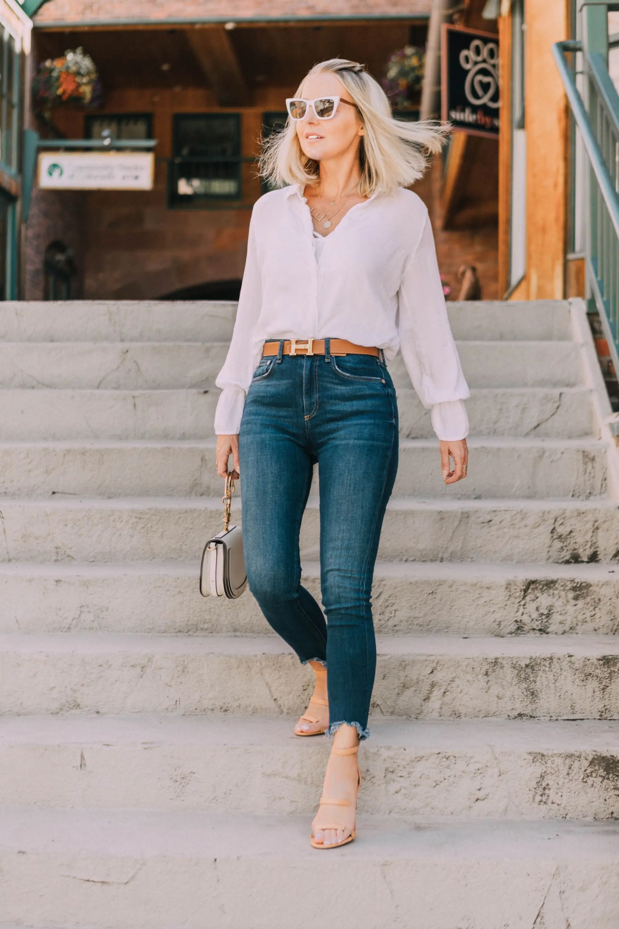 Tamara Mellon, Fashion blogger Erin Busbee of BusbeeStyle.com wearing dark was skinny jeans and white top with stunning Tamara Mellon Frontline heels in Telluride, Colorado