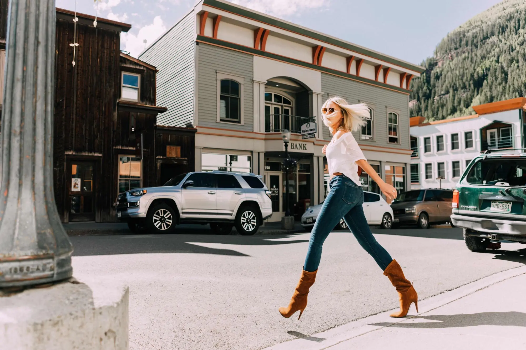 Tamara Mellon, Fashion blogger Erin Busbee of BusbeeStyle.com wearing dark was skinny jeans and white top with stunning Tamara Mellon Frontline heels in Telluride, Colorado