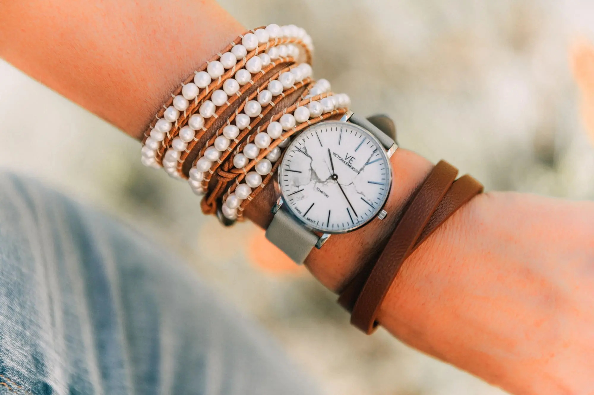 Victoria Emerson, Fashion blogger Erin Busbee of BusbeeStyle.com wearing a marble face watch, pearl wrap bracelet, brown leather wrap bracelet, and Cairo cuff from Victoria Emerson in Telluride, CO