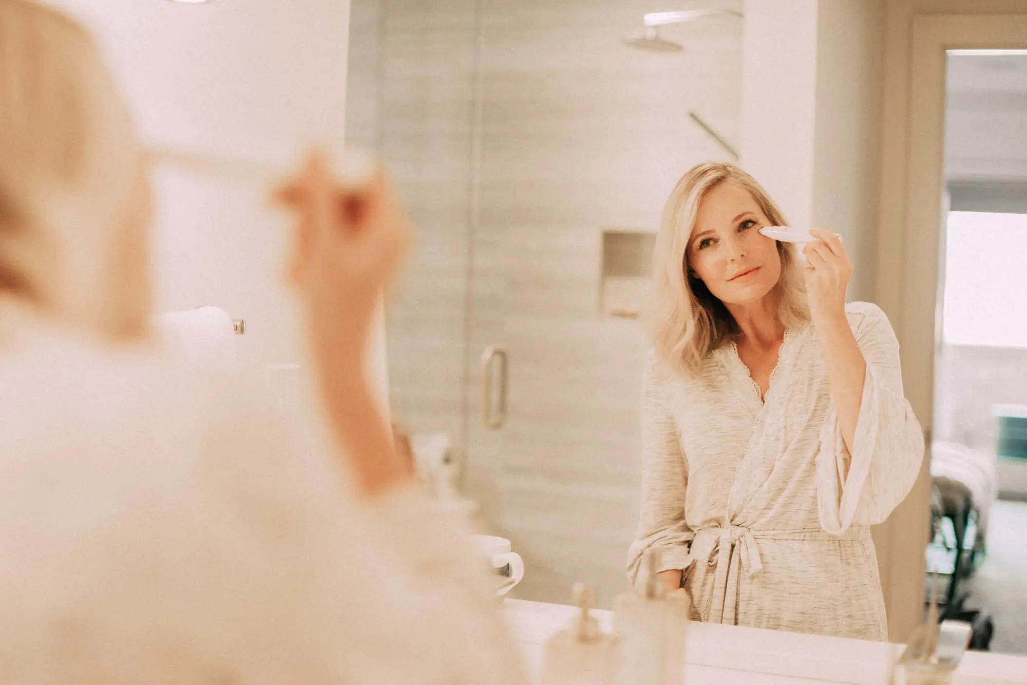 NuFace Fix, Fashion Blogger Erin Busbee of BusbeeStyle.com featuring the NuFace Fix, using it around her eye area to reduce fine lines in bathroom in Telluride, CO