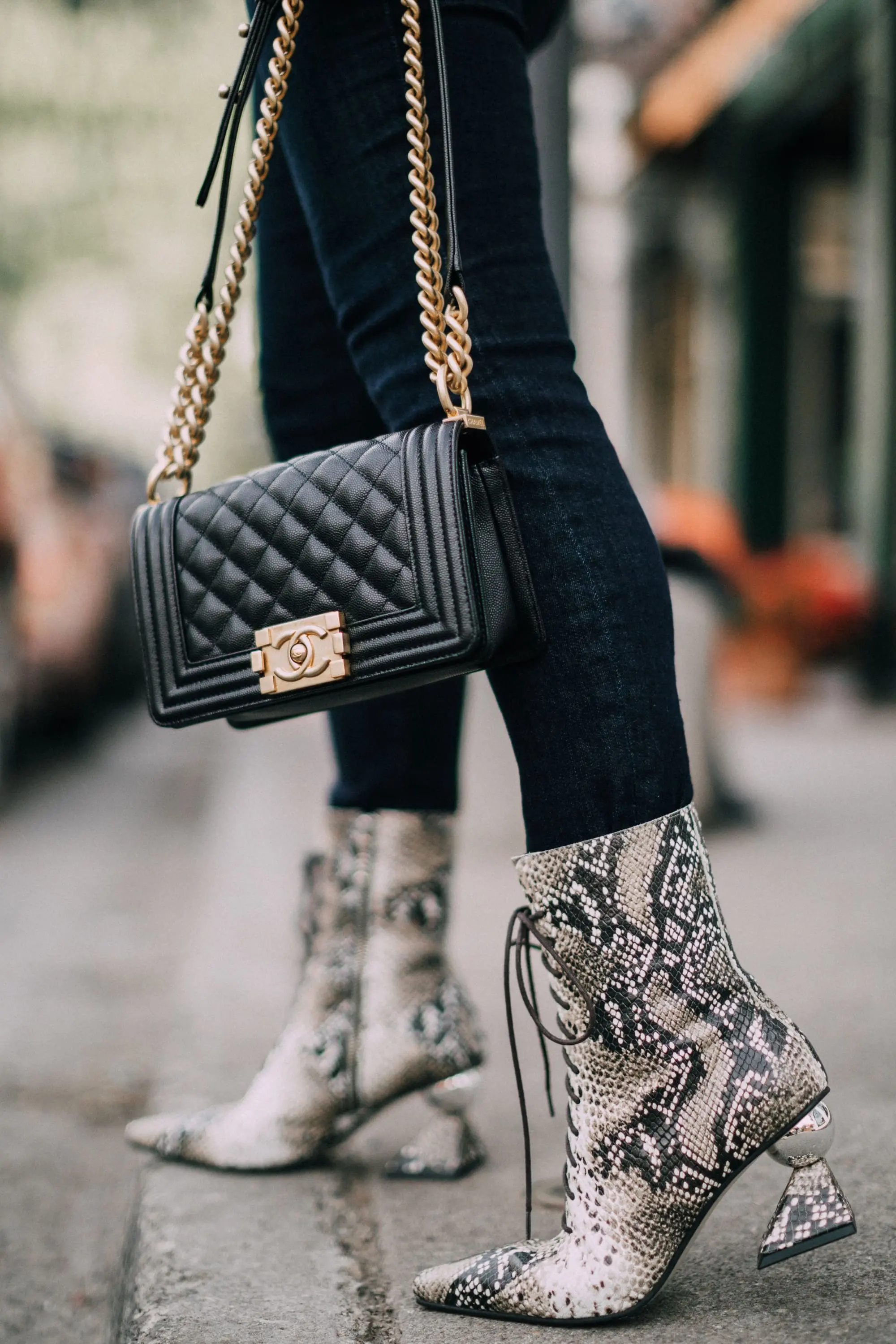 Yuul Yie, Fashion blogger Erin Busbee of BusbeeStyle.com wearing dark wash skinny jeans by L'Agence, leopard print bodysuit by ASTR the label, black Chanel boy bag, and Yuul Yie python boots in Telluride, CO