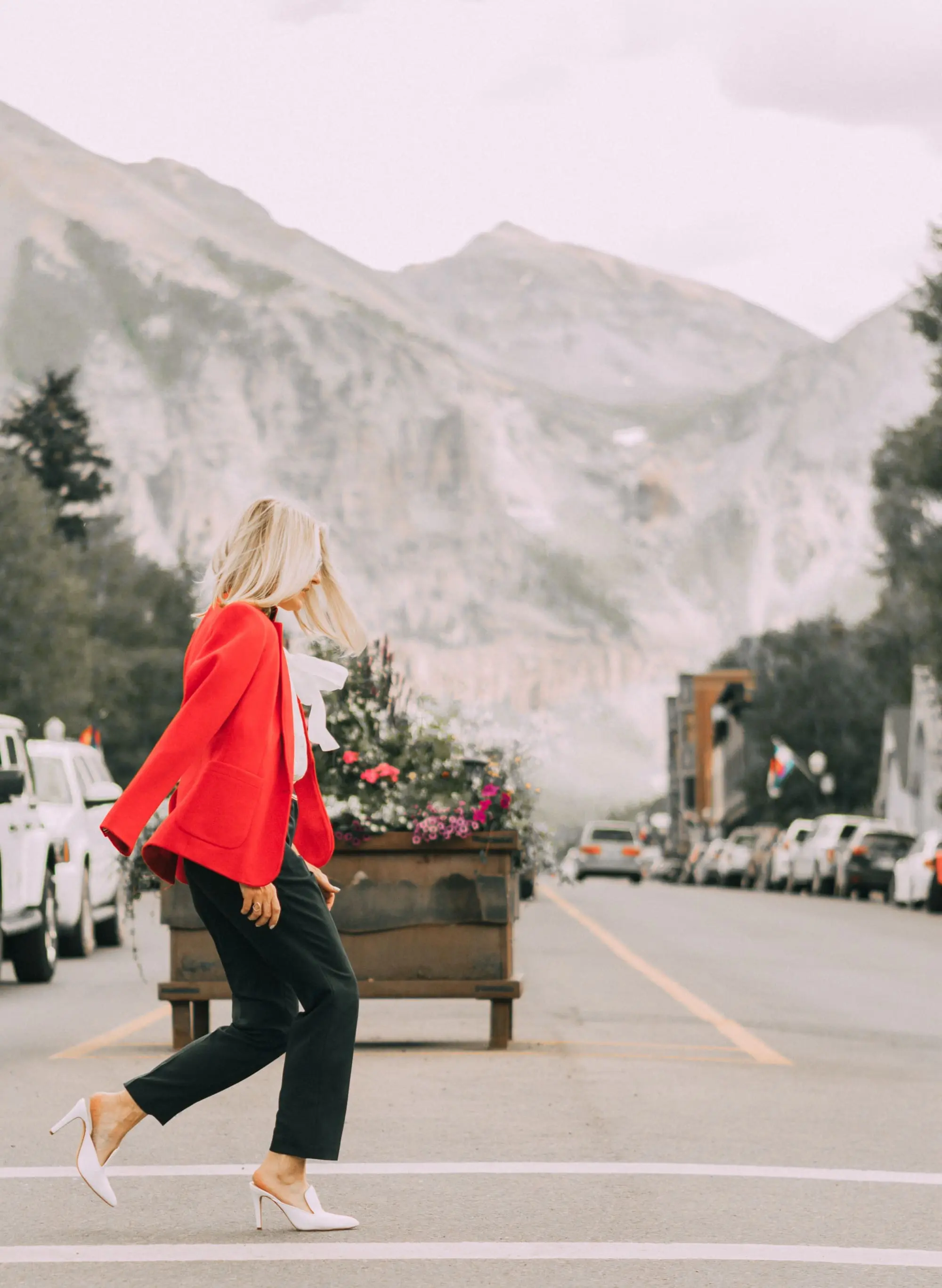 Tommy Hilfiger colorful office outfits featuring a red blazer, navy chino ankle pants, white bow blouse and white mules on fashion blogger over 40Fashion blogger over 40 Erin Busbee of Busbee Style