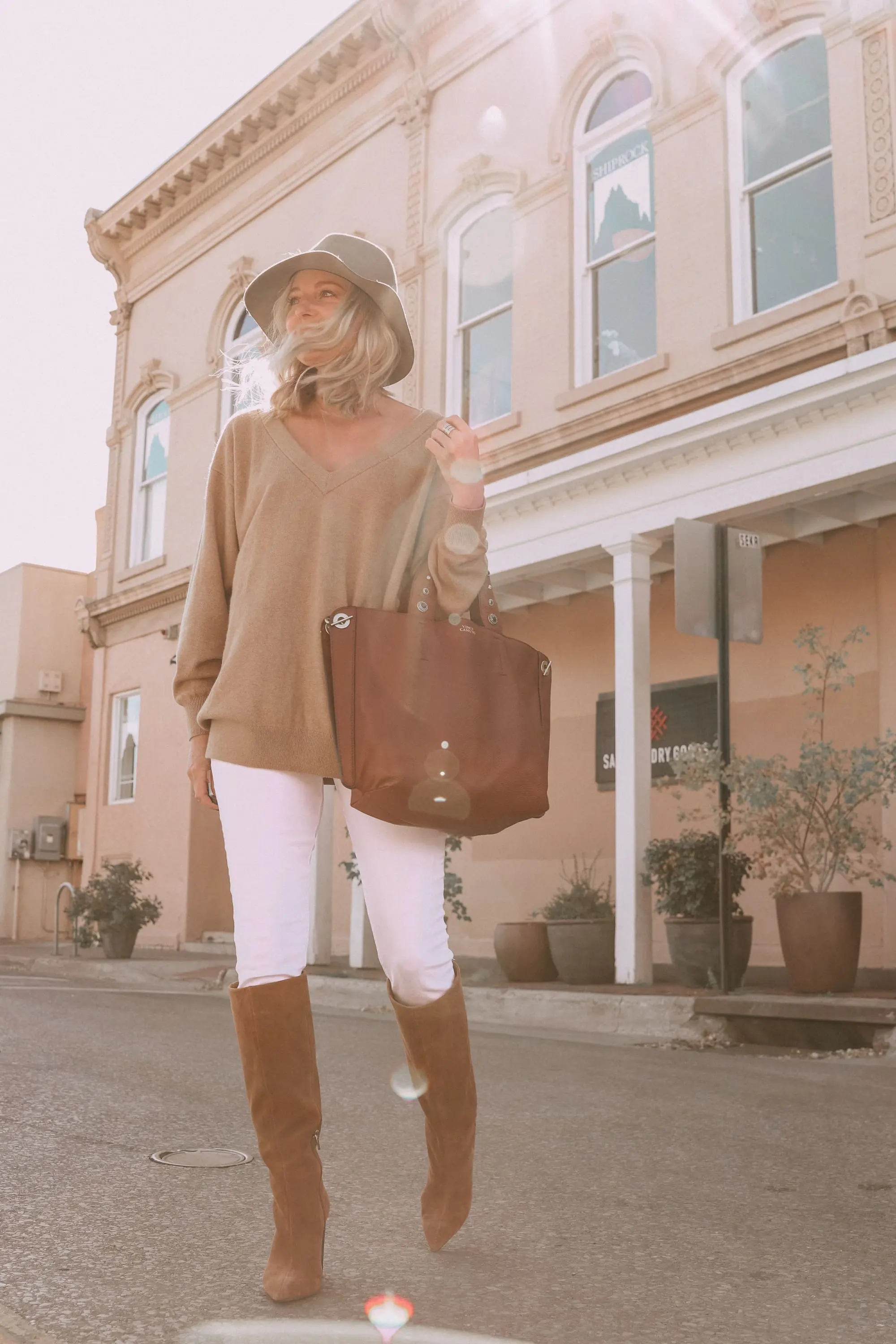 Brown Accessories For Fall, Fashion blogger Erin Busbee of BusbeeStyle.com wearing brown boots and brown tote from Vince Camuto with white jeans, camel sweater, leopard scarf, and Rag & bone hat in Santa Fe, New Mexico