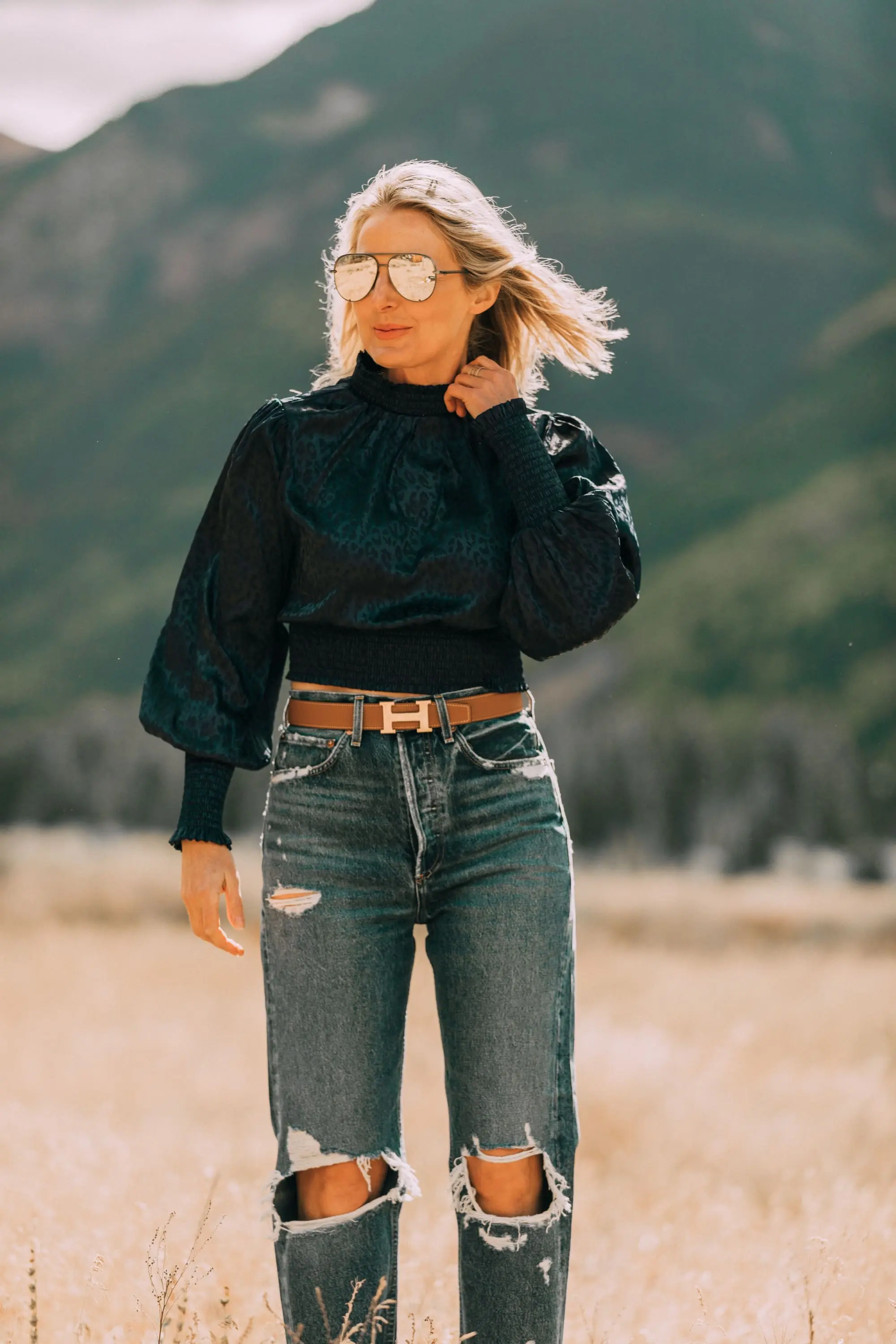 High Neckline Tops, fashion blogger Erin Busbee of BusbeeStyle.com wearing a high neck smocked leopard print blouse by Aqua from Bloomingdale's with agolde baggy jeans, hermes belt, and neutral booties in Telluride, CO