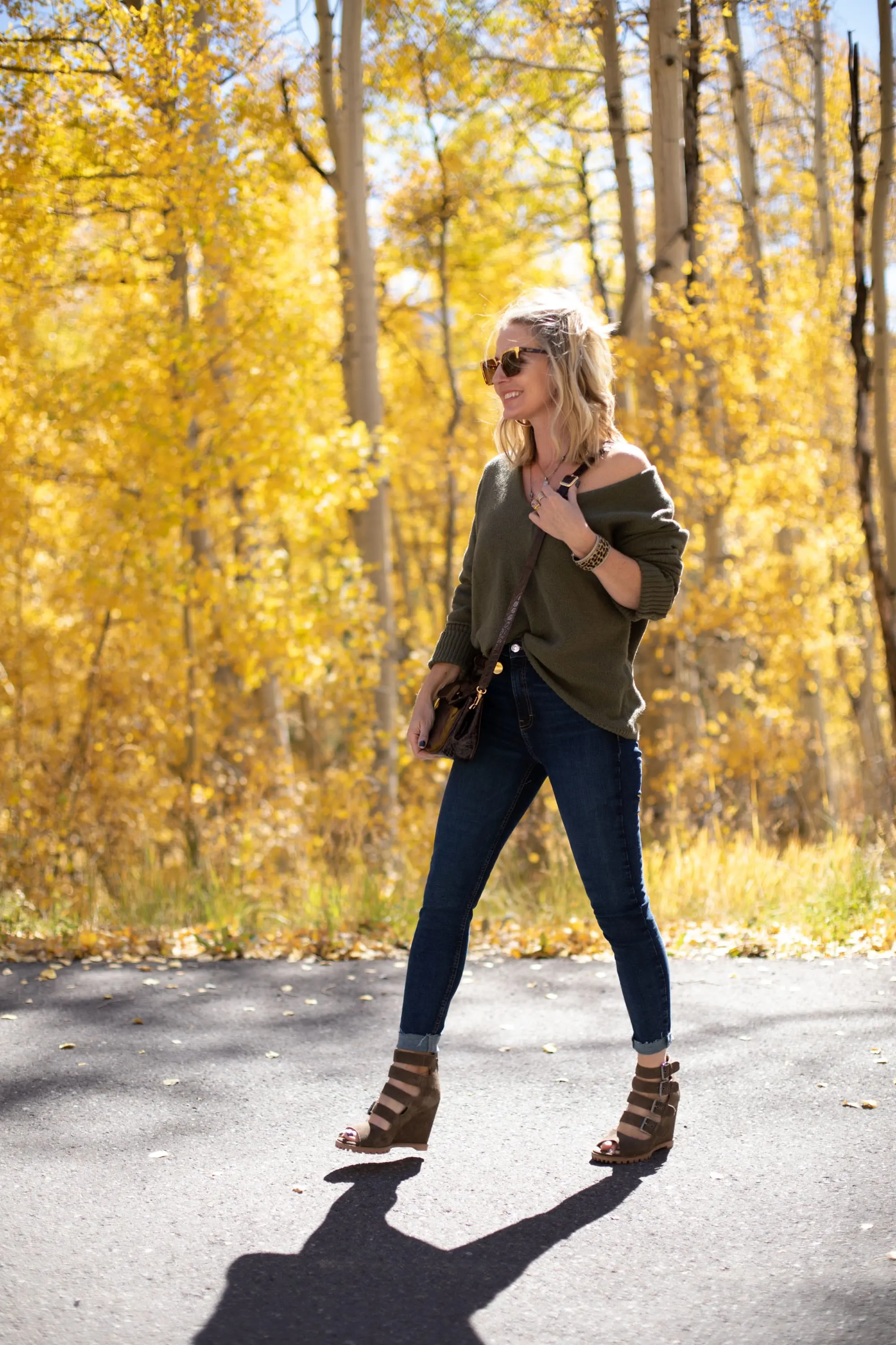 Shoes For Busy Women, Fashion blogger Erin Busbee of BusbeeStyle.com wearing Linea Paolo Wisteria Buckle Wedge Sandals with rag & bone skinny jeans, Something Navy green sweater, Staud Madeline Croc Embossed crossbody, and Quay sunglasses in Telluride, CO