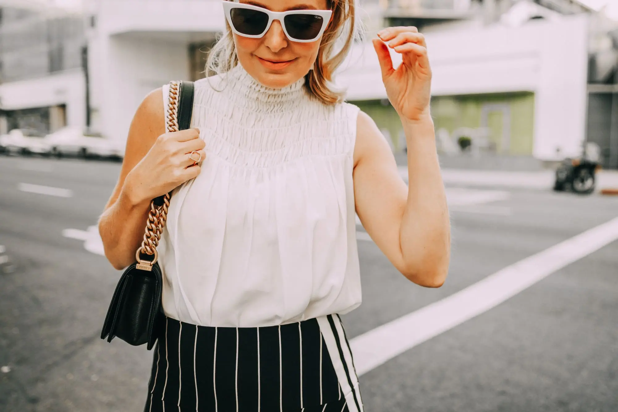 smocked high neckline white sleeveless blouse outfit with black and white stripe skirt
