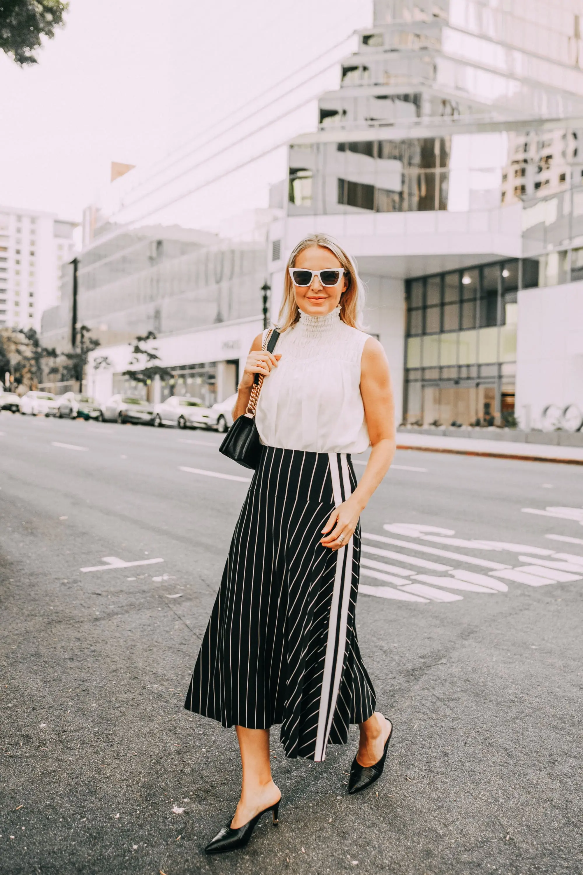 smocked high neckline white sleeveless blouse outfit with black and white stripe skirt