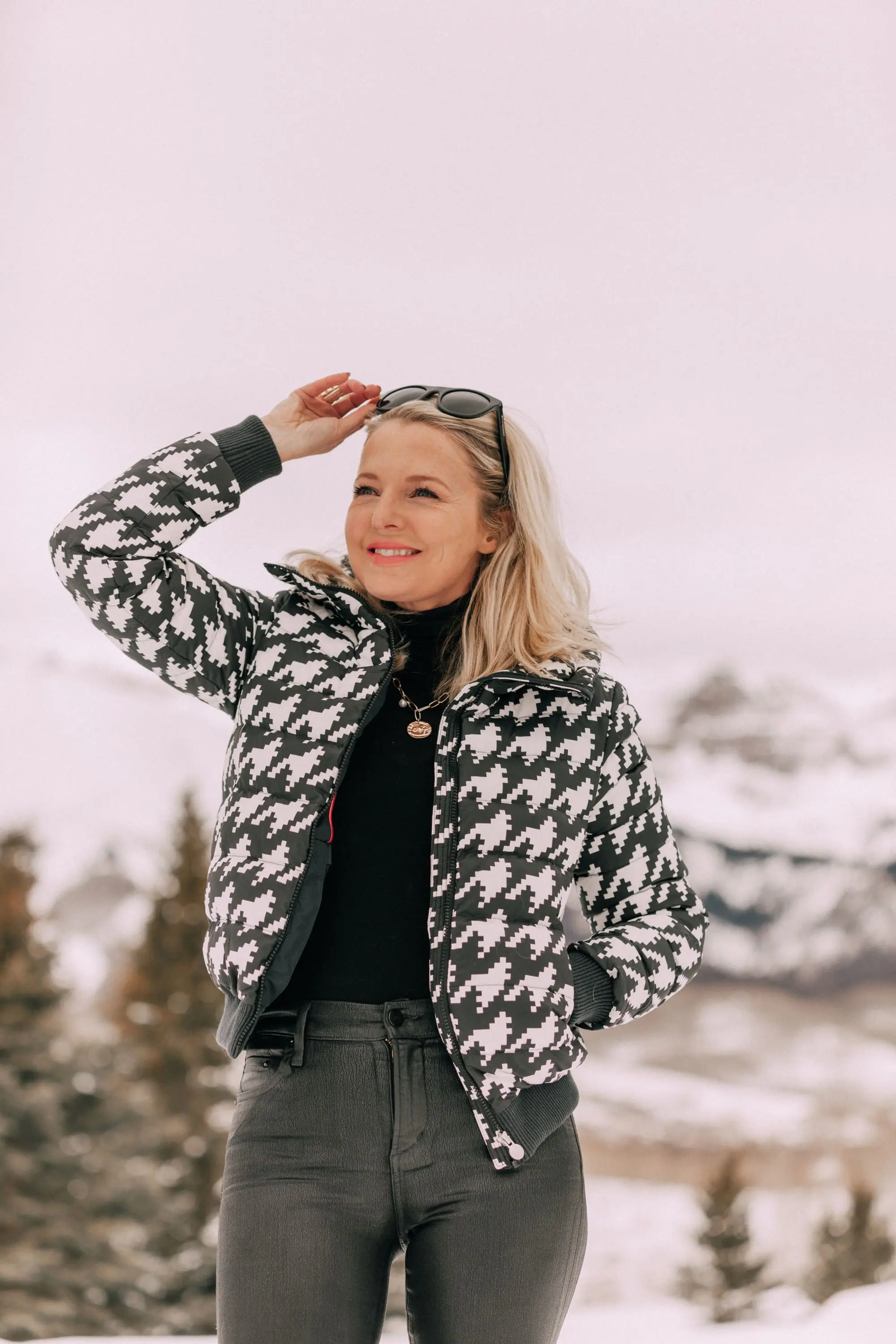 Chic Ski Brand, Fashion blogger Erin Busbee of BusbeeStyle.com wearing black Rocket leatherette Skinny Jeans by Citizens of Humanity with a black cashmere turtleneck sweater by Aqua, and a houndstooth puffer jacket by Perfect Moment from Shopbop, and Ugg wedge boots in the snow in Telluride, CO