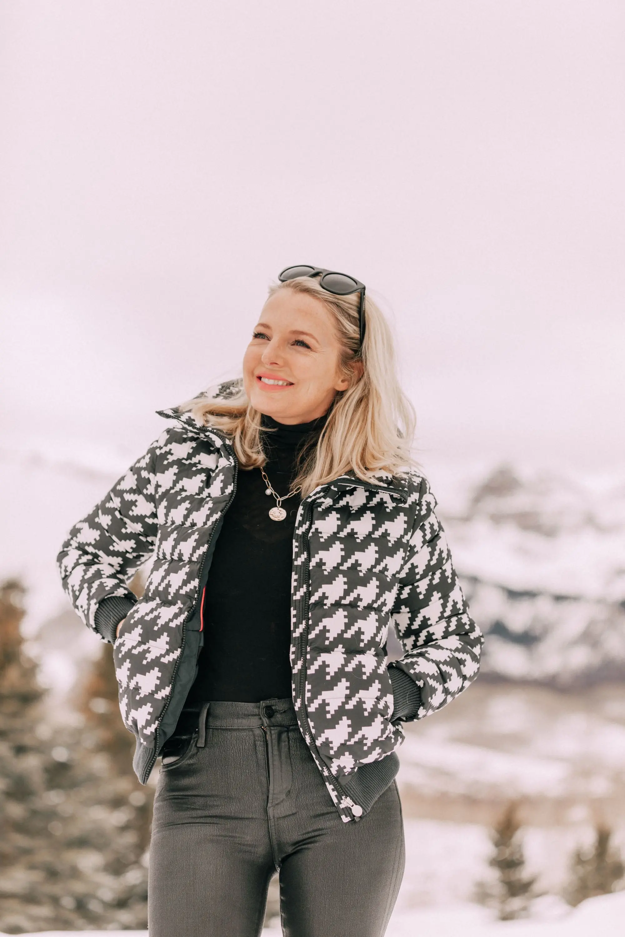 Chic Ski Brand, Fashion blogger Erin Busbee of BusbeeStyle.com wearing black Rocket leatherette Skinny Jeans by Citizens of Humanity with a black cashmere turtleneck sweater by Aqua, and a houndstooth puffer jacket by Perfect Moment from Shopbop, and Ugg wedge boots in the snow in Telluride, CO