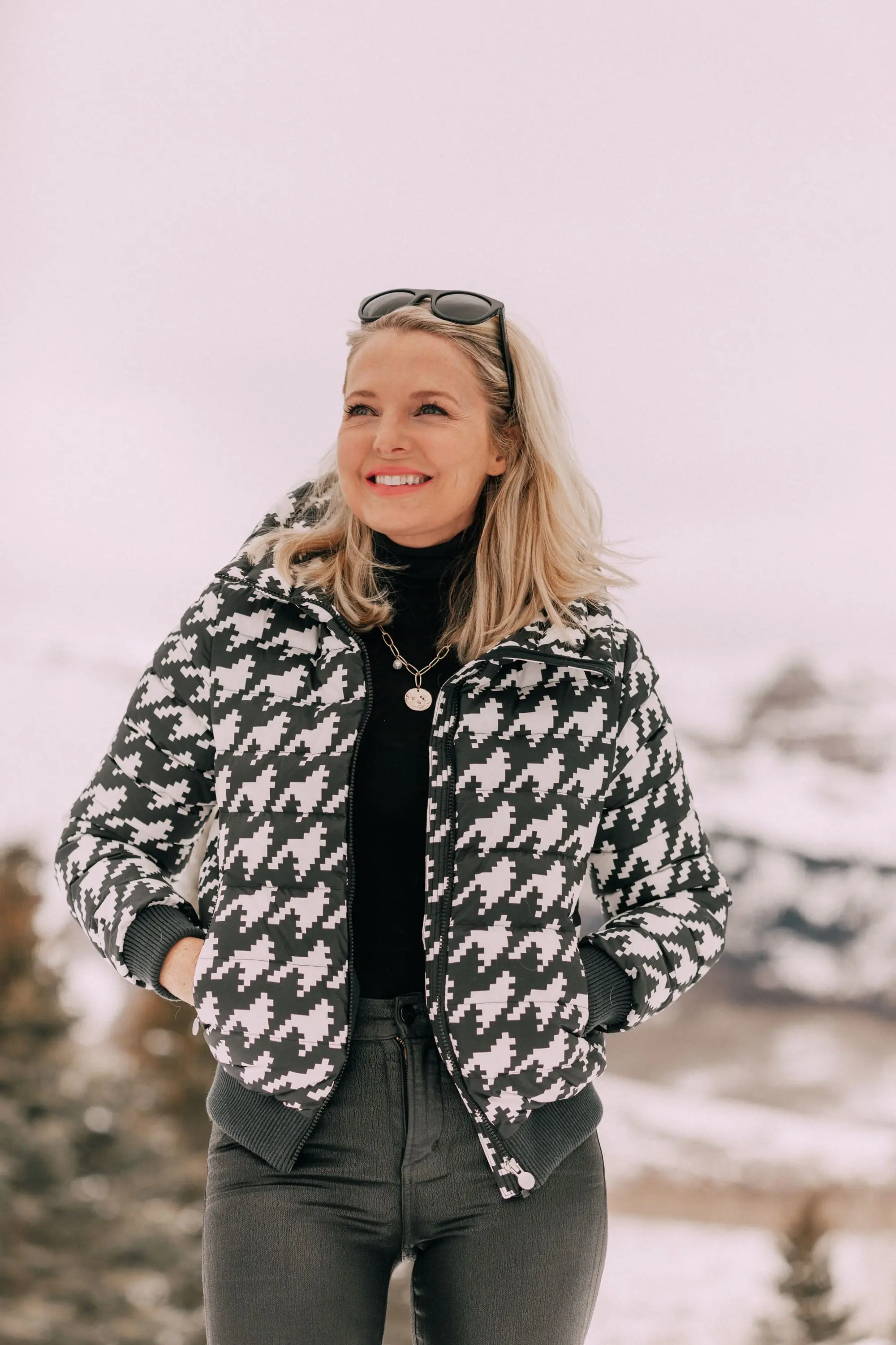 stylish puffer coat outfit, Fashion blogger over 40 wearing Perfect Moment houndstooth puffer jacket, black Citizens of Humanity Rocket leatherette Skinny Jeans with a black cashmere turtleneck sweater by Aqua, in snow in Telluride, CO