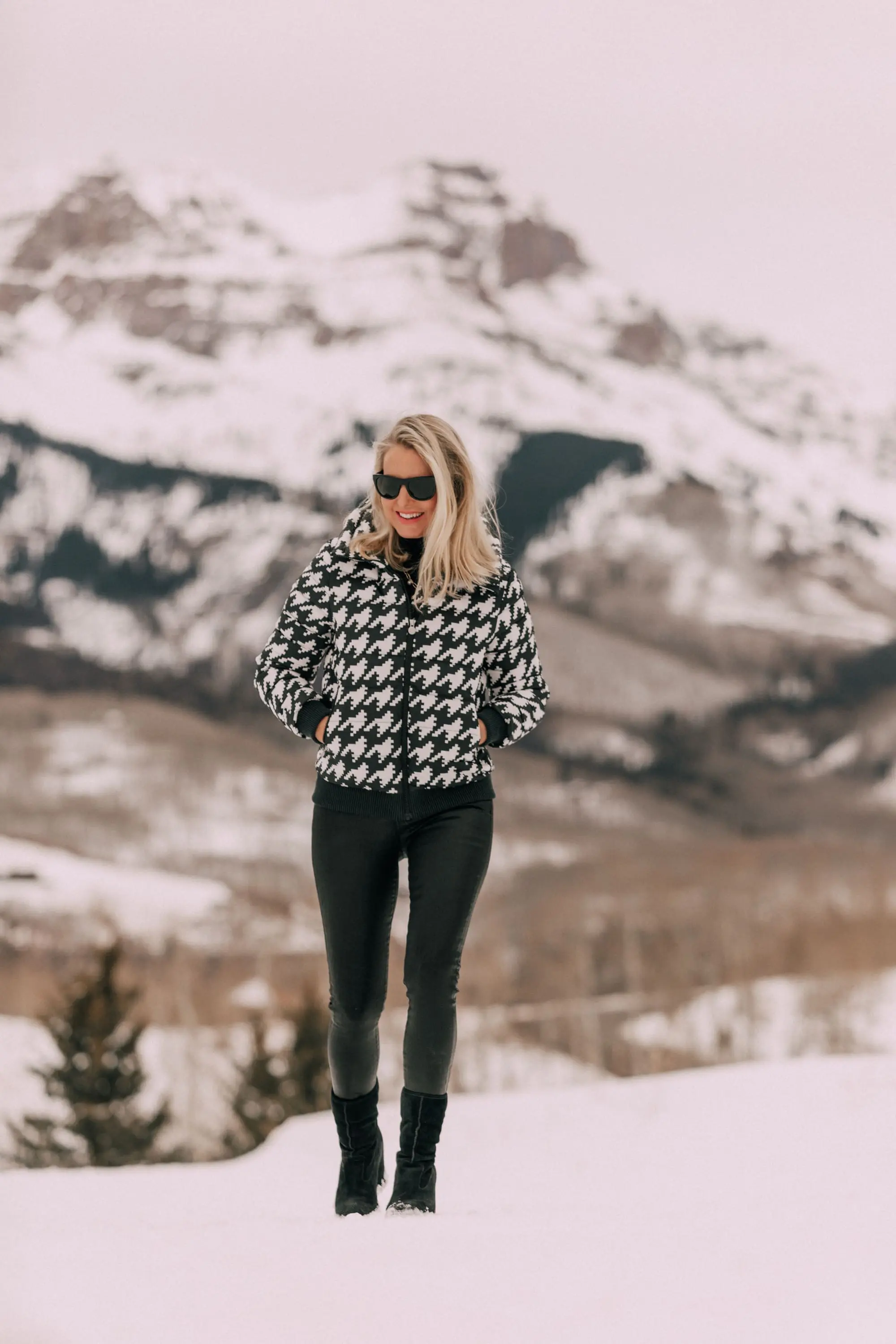 stylish puffer coat outfit, Fashion blogger over 40 wearing Perfect Moment houndstooth puffer jacket, black Citizens of Humanity Rocket leatherette Skinny Jeans with a black cashmere turtleneck sweater by Aqua, in snow in Telluride, CO