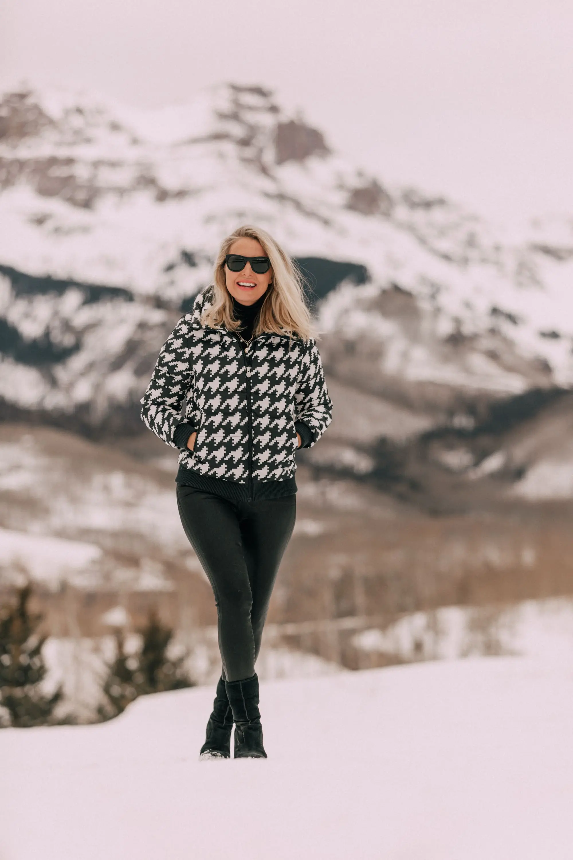 Chic Ski Brand, Fashion blogger Erin Busbee of BusbeeStyle.com wearing black Rocket leatherette Skinny Jeans by Citizens of Humanity with a black cashmere turtleneck sweater by Aqua, and a houndstooth puffer jacket by Perfect Moment from Shopbop, and Ugg wedge boots in the snow in Telluride, CO