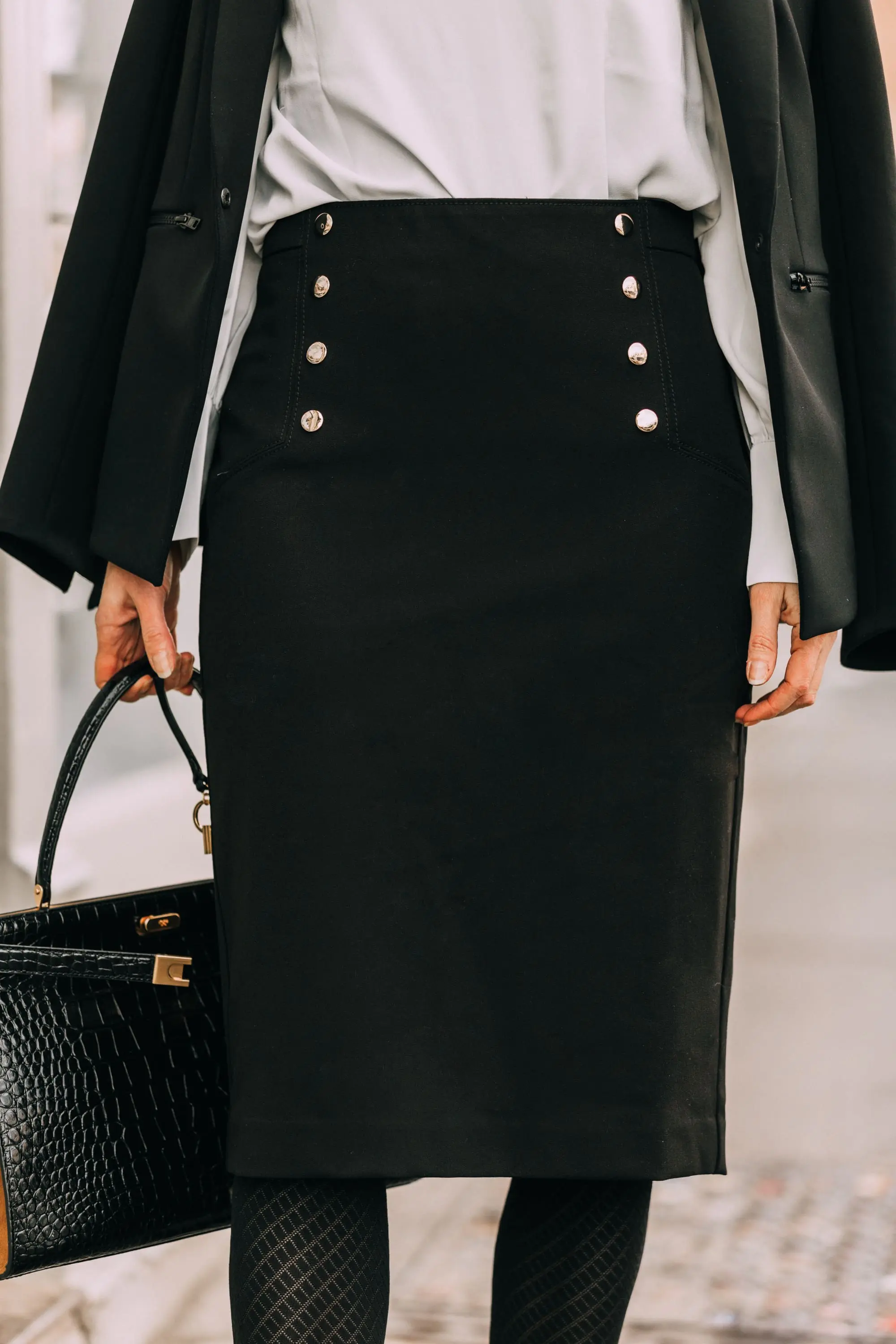 Wardrobe Basics, Fashion blogger Erin Busbee of BusbeeStyle.com sharing wardrobe basics from Ann Taylor wearing a black pencil skirt with sailir buttons, a white ruffle neck blouse, classic black blazer, black tights, and black pumps all from Ann Taylor in Telluride, Colorado