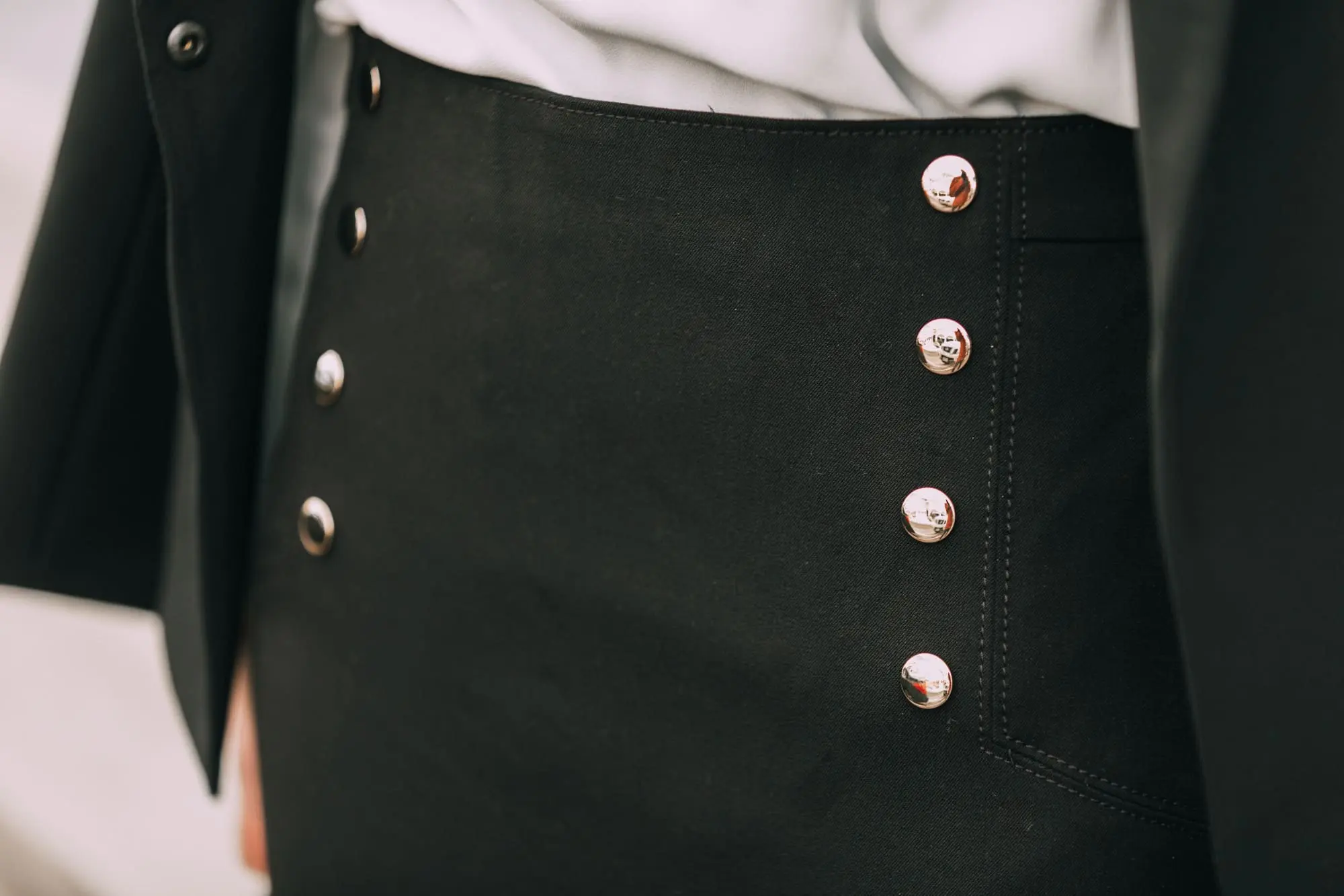 Wardrobe Basics, Fashion blogger Erin Busbee of BusbeeStyle.com sharing wardrobe basics from Ann Taylor wearing a black pencil skirt with sailir buttons, a white ruffle neck blouse, classic black blazer, black tights, and black pumps all from Ann Taylor in Telluride, Colorado