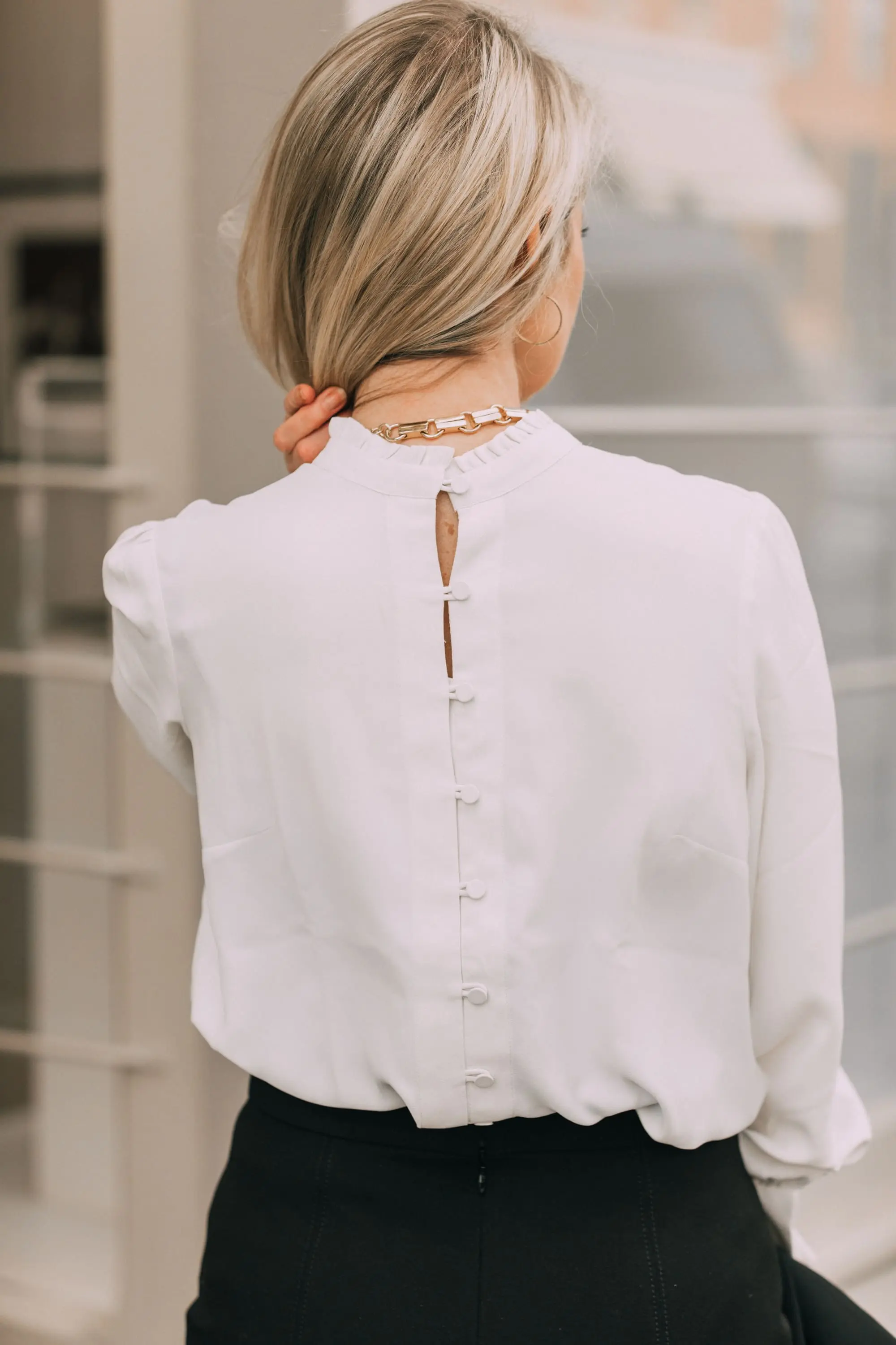 Wardrobe Basics, Fashion blogger Erin Busbee of BusbeeStyle.com sharing wardrobe basics from Ann Taylor wearing a black pencil skirt with sailir buttons, a white ruffle neck blouse, classic black blazer, black tights, and black pumps all from Ann Taylor in Telluride, Colorado