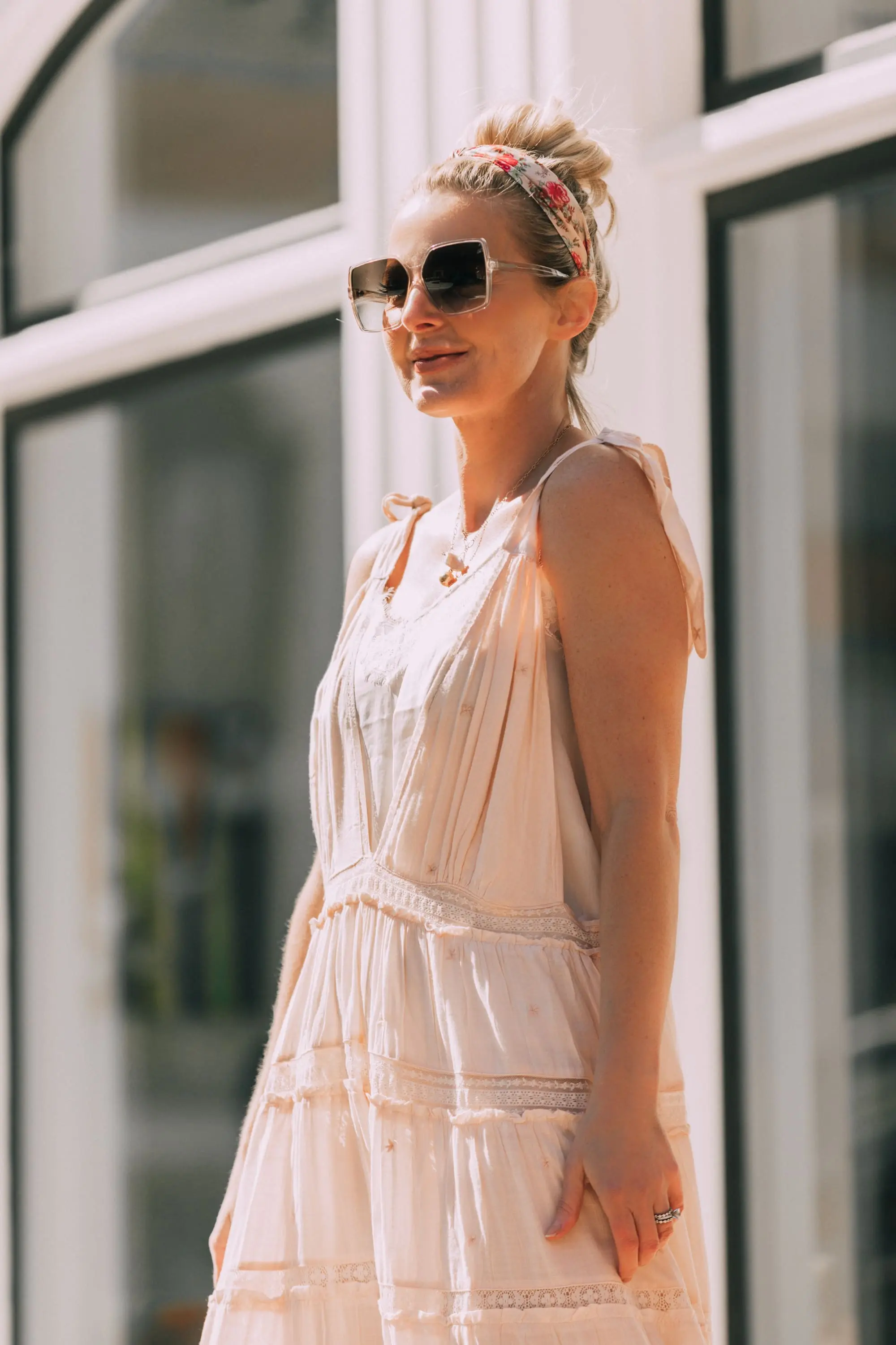 How To Wear A Maxi Dress, Fashion blogger Erin Busbee of BusbeeStyle.com wearing a peach Free People Lily of the Valley Maxi dress with brown block heel sandals, white lace cami underneath, floral headband, gold necklace, and sunglasses walking in Telluride, Colorado