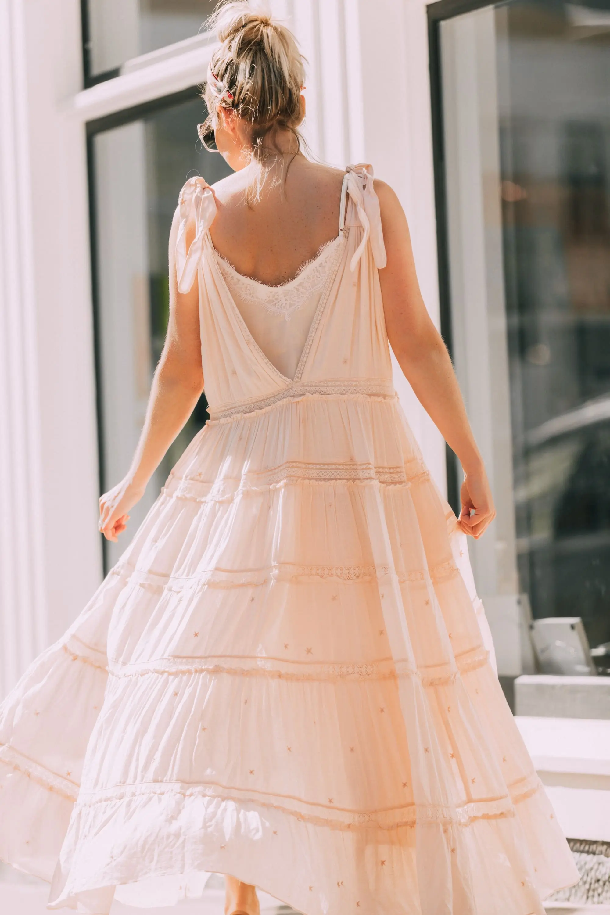 How To Wear A Maxi Dress, Fashion blogger Erin Busbee of BusbeeStyle.com wearing a peach Free People Lily of the Valley Maxi dress with brown block heel sandals, white lace cami underneath, floral headband, gold necklace, and sunglasses walking in Telluride, Colorado
