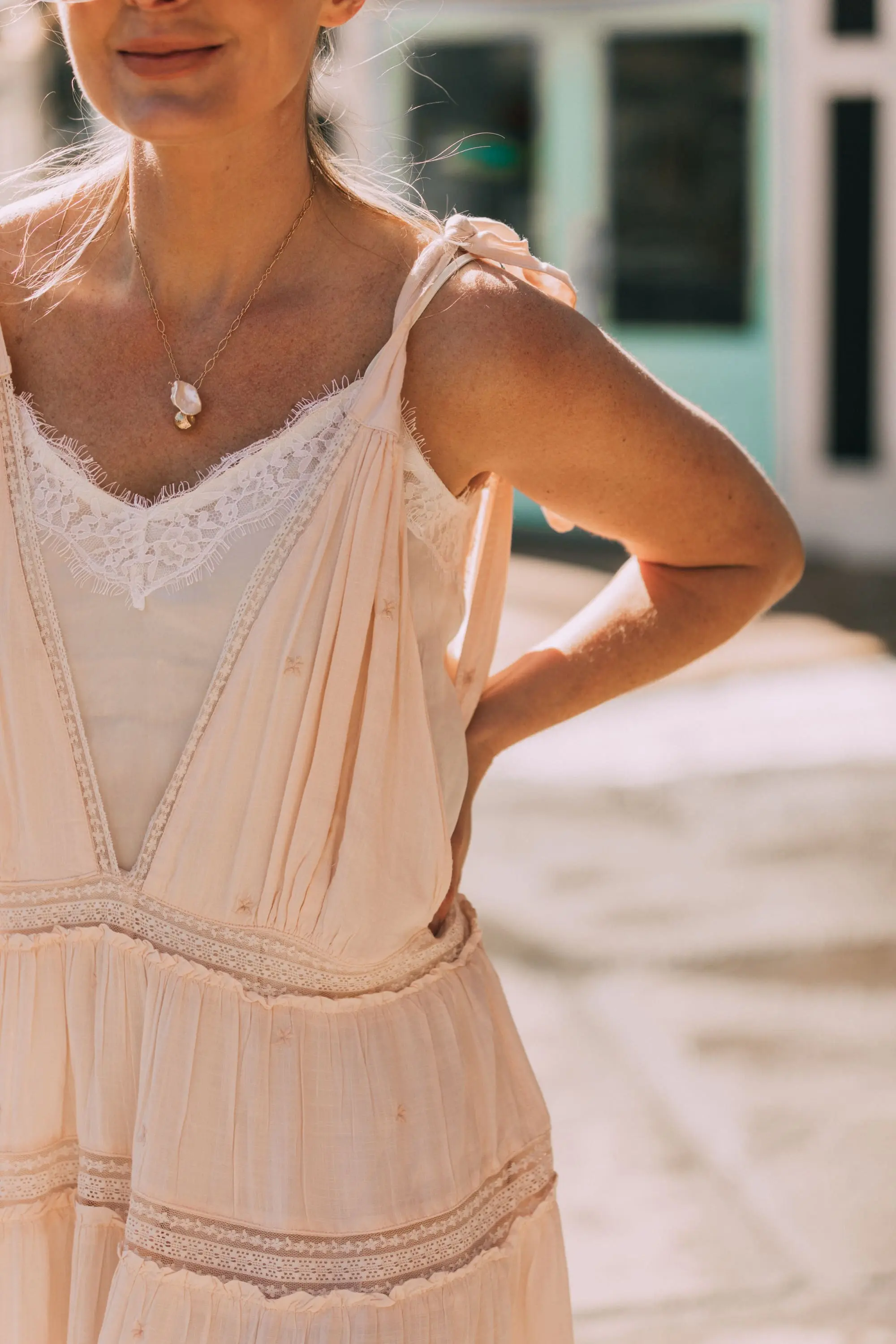 How To Wear A Maxi Dress, Fashion blogger Erin Busbee of BusbeeStyle.com wearing a peach Free People Lily of the Valley Maxi dress with brown block heel sandals, white lace cami underneath, floral headband, gold necklace, and sunglasses walking in Telluride, Colorado