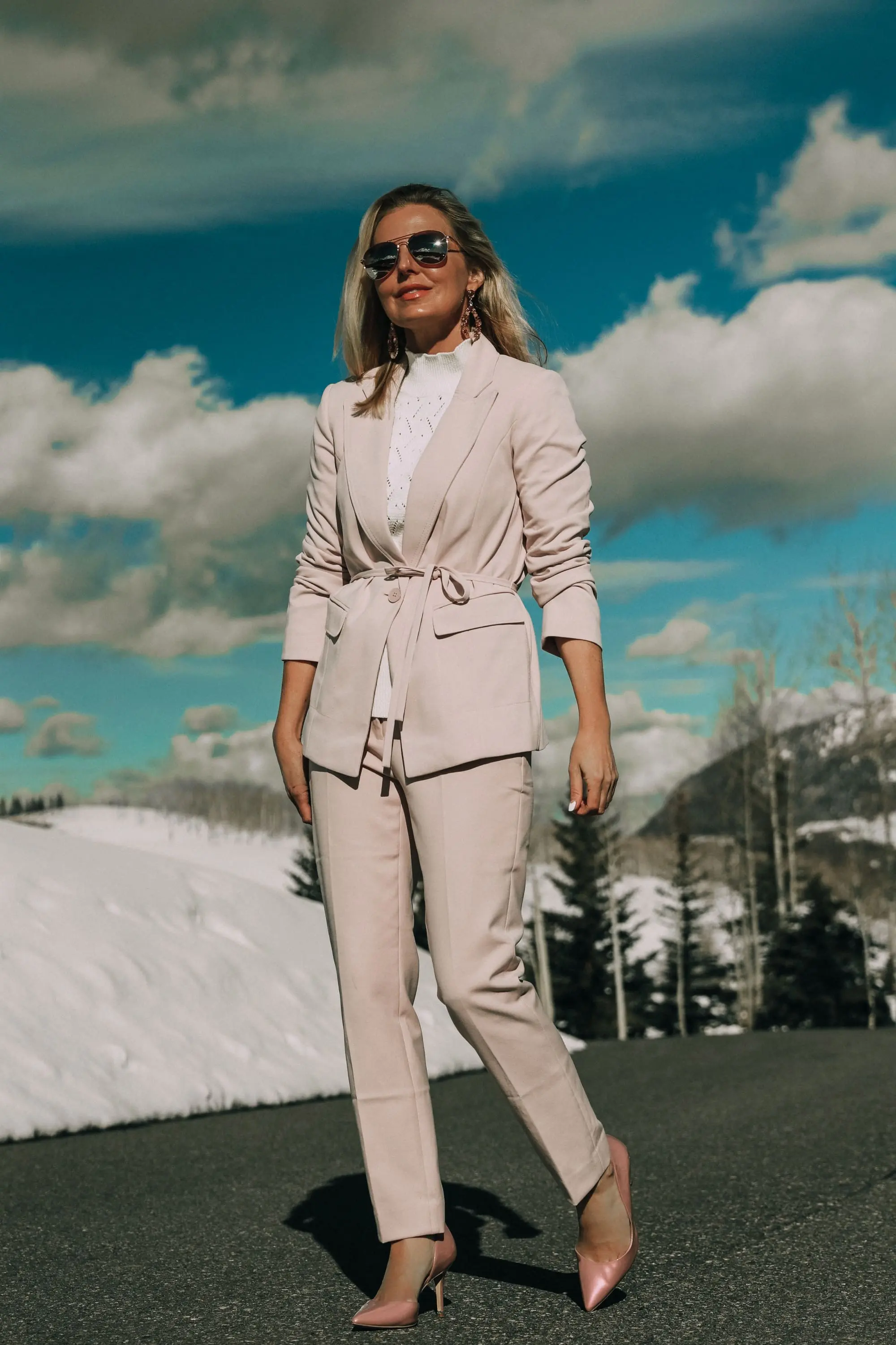 Pink Office Outfit, Fashion blogger Erin Busbee of BusbeeStyle.com wearing a pink power suit from White House Black Market, including a pink belted blazer, pink soft stretch pants, white puff sleeve sweater dress, pink pumps, pink earrings, and aviator sunglasses in Telluride, Colorado