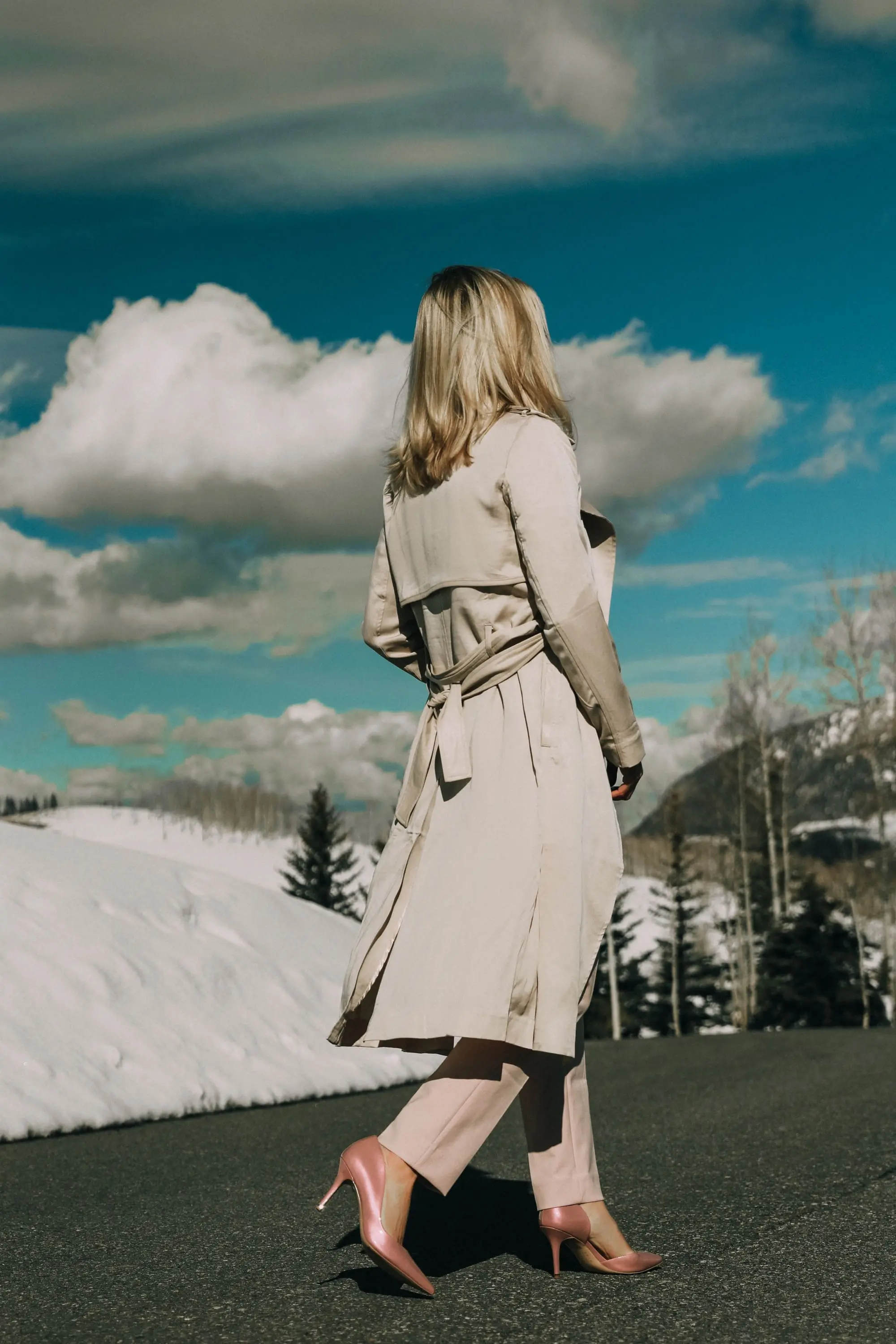 Pink Office Outfit, Fashion blogger Erin Busbee of BusbeeStyle.com wearing a pink power suit from White House Black Market, including a pink belted blazer, pink soft stretch pants, white puff sleeve sweater dress, pink pumps, pink earrings, and aviator sunglasses, and a tan lightweight trench in Telluride, Colorado