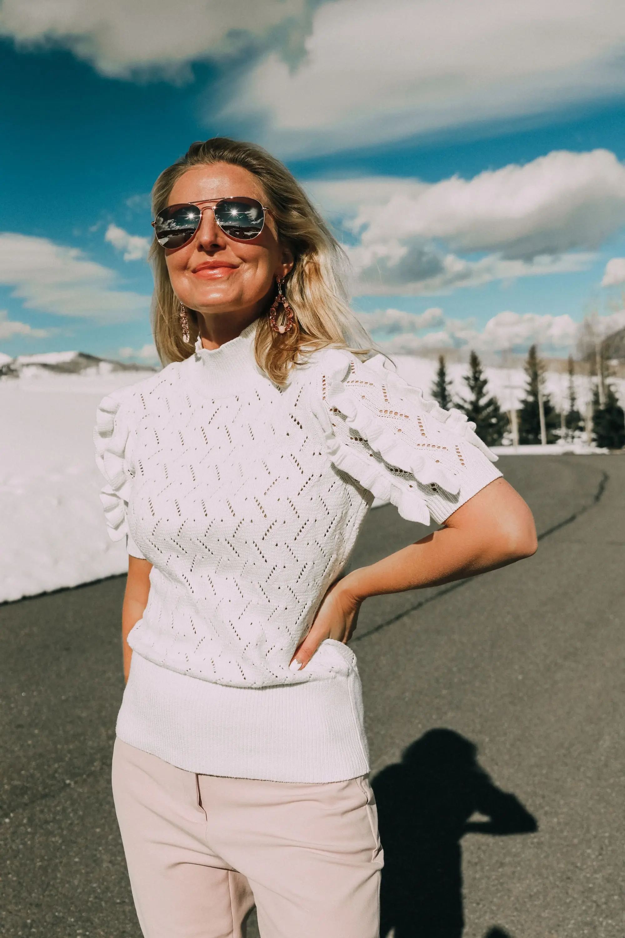 Pink Office Outfit, Fashion blogger Erin Busbee of BusbeeStyle.com wearing a pink power suit from White House Black Market, including a pink belted blazer, pink soft stretch pants, white puff sleeve sweater dress, pink pumps, pink earrings, and aviator sunglasses in Telluride, Colorado