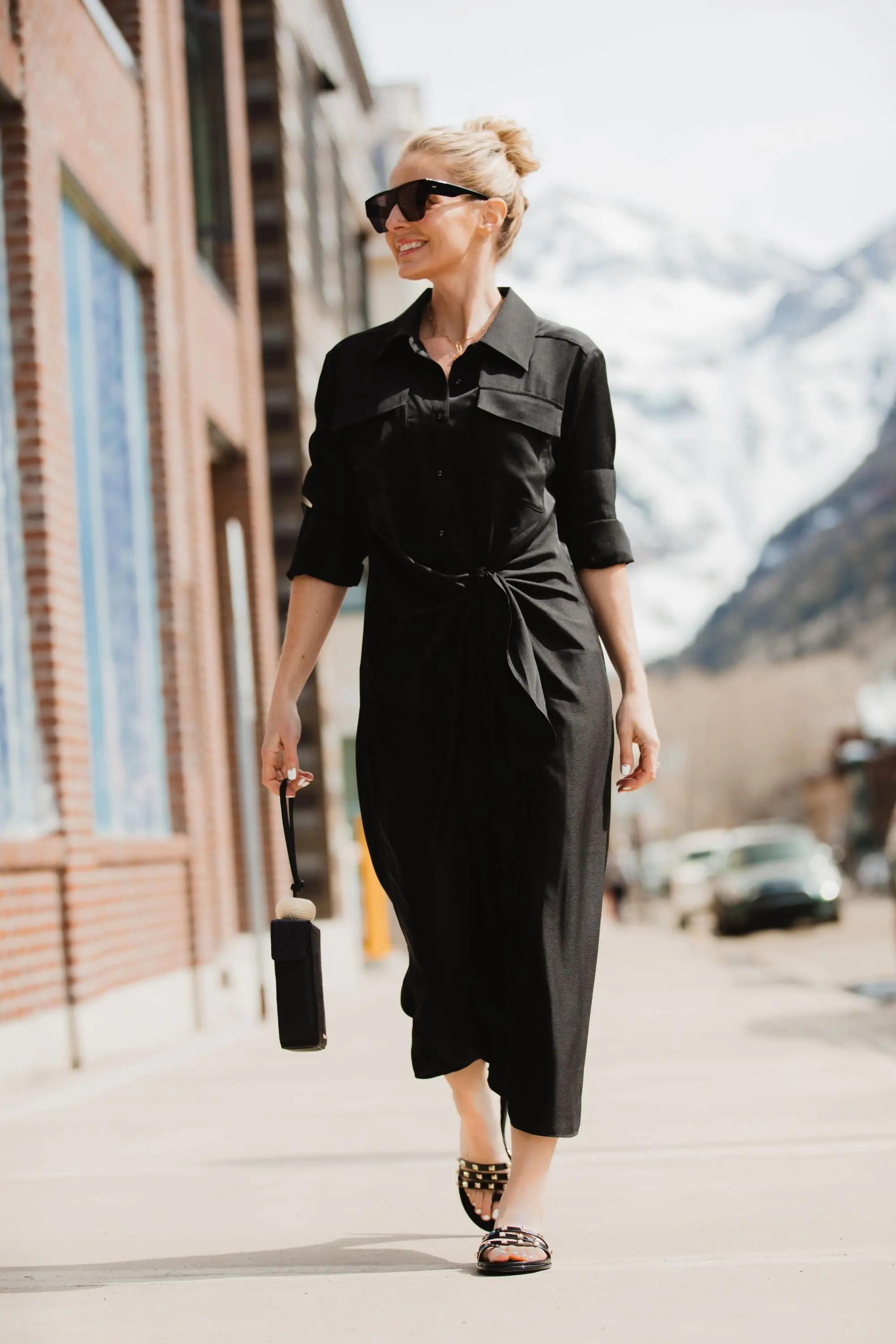 Spring Accessories, Fashion blogger Erin Busbee of BusbeeStyle.com wearing a black L'Academie shirt dress with black studded strappy slides and black bracelet bag from Vince Camuto in Telluride, Colorado