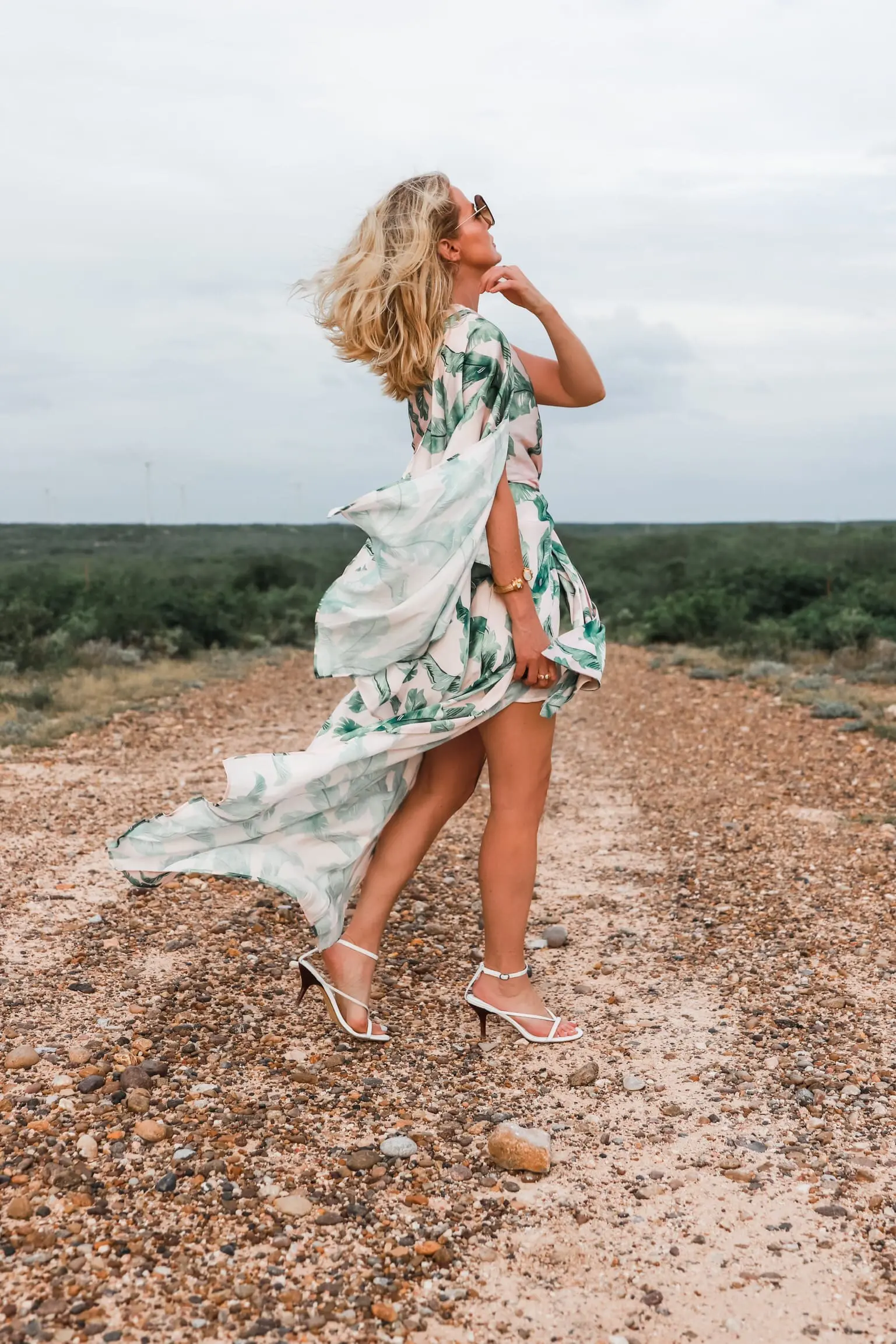 Palm Print Dress, fashion blogger Erin Busbee of Busbee Style wearing a pink and green palm print dress by Significant other with white sandals on a ranch in south Texas