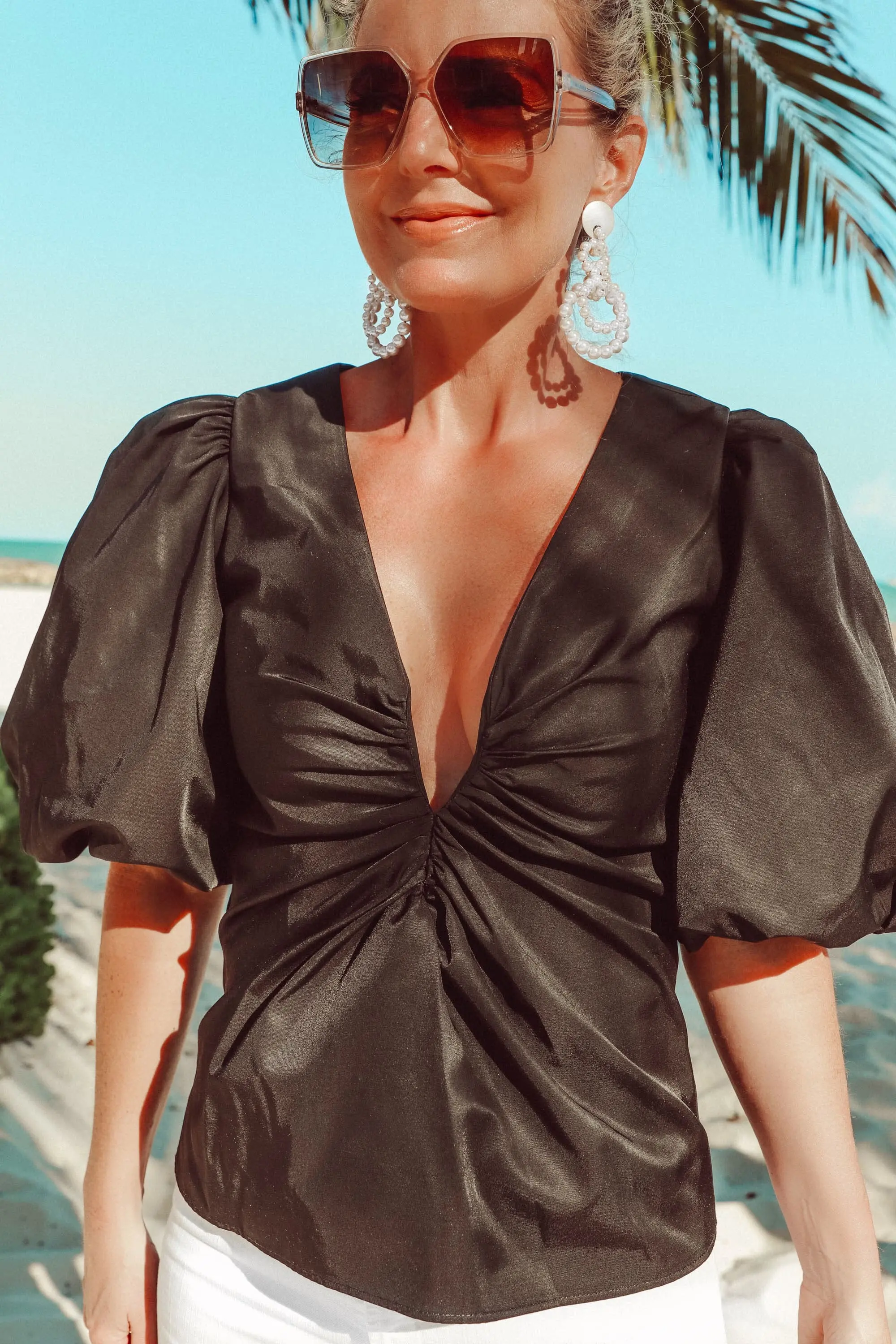puff sleeve Amanda Uprichard Neveah black blouse, statement sleeve v-neck top worn white jeans