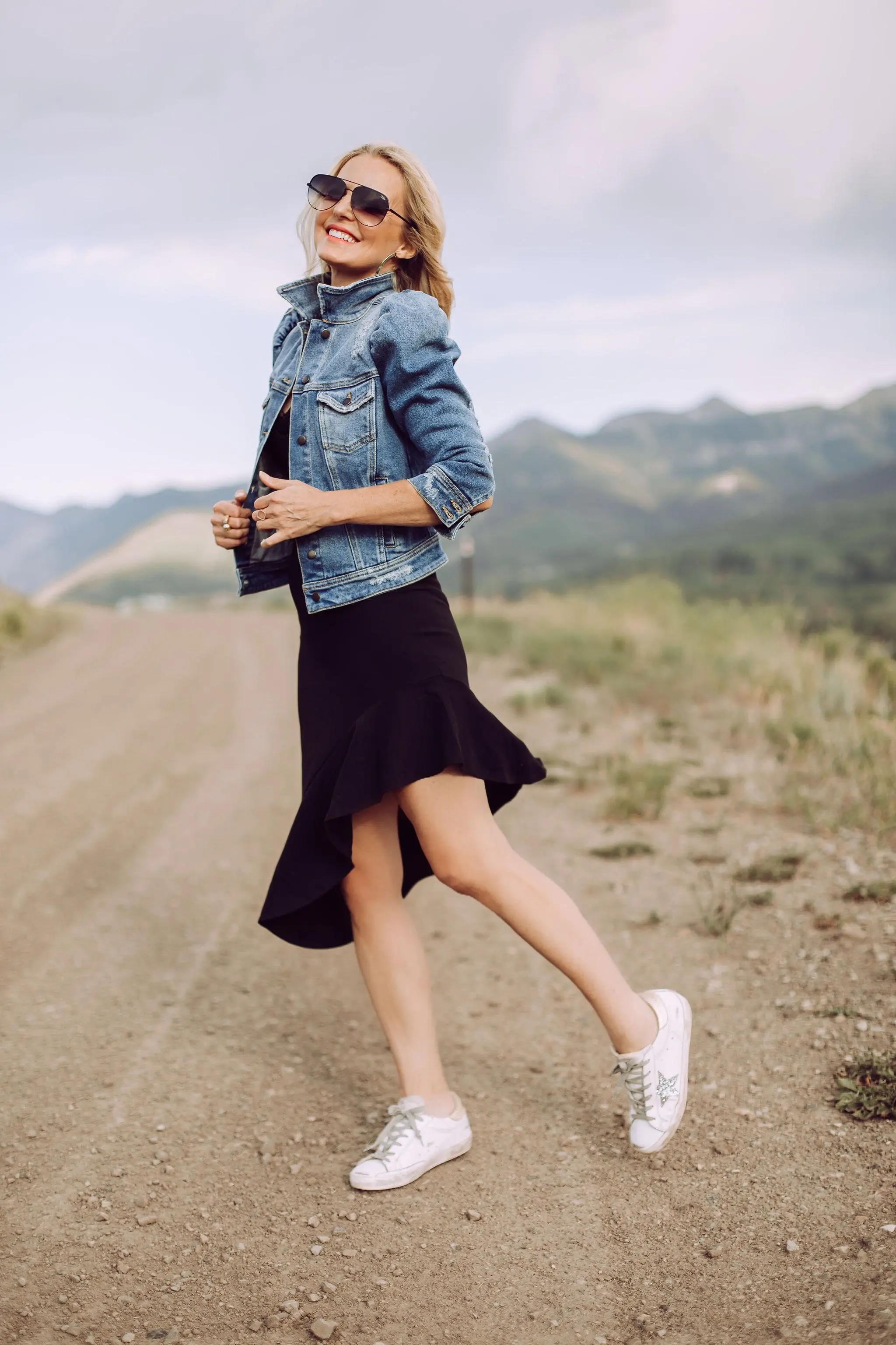Day To Date Night Outfits, Fashion blogger Erin Busbee of Busbee Style wearing a black susana monaco dress with golden goose sneakers, retrofete denim puff sleeve jacket and aviator sunglasses in Telluride, Colorado