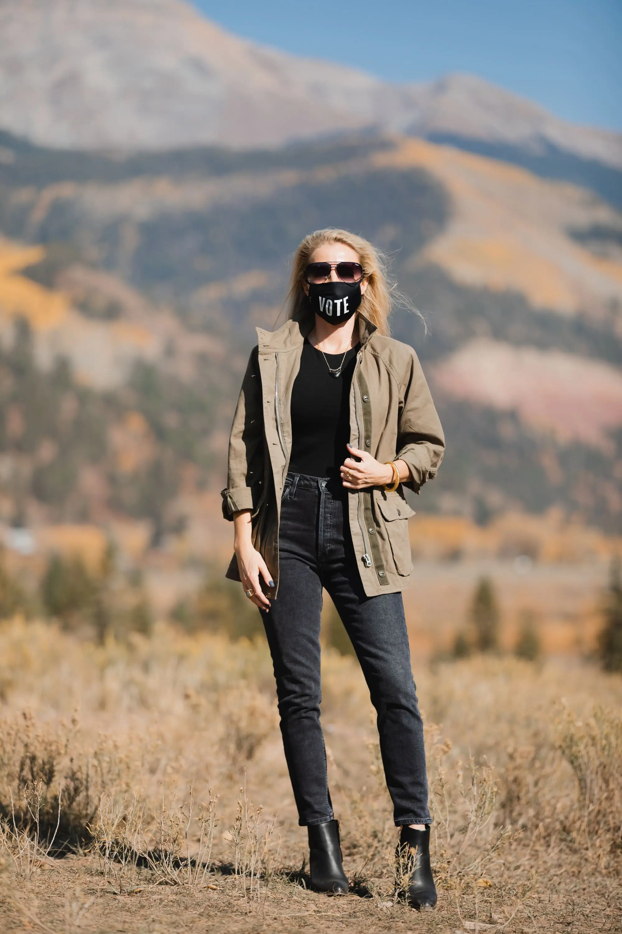 How To Wear A Cargo Jacket, Erin Busbee of Busbee Style wearing a green cargo jacket by rag & bone, black muscle tee tank by Aqua, gray wash Nico slim fit jeans by Agolde, QUAY sunglasses, Vote mask, and Alexander Wang cutout booties from Bloomingdale's in Telluride, Colorado