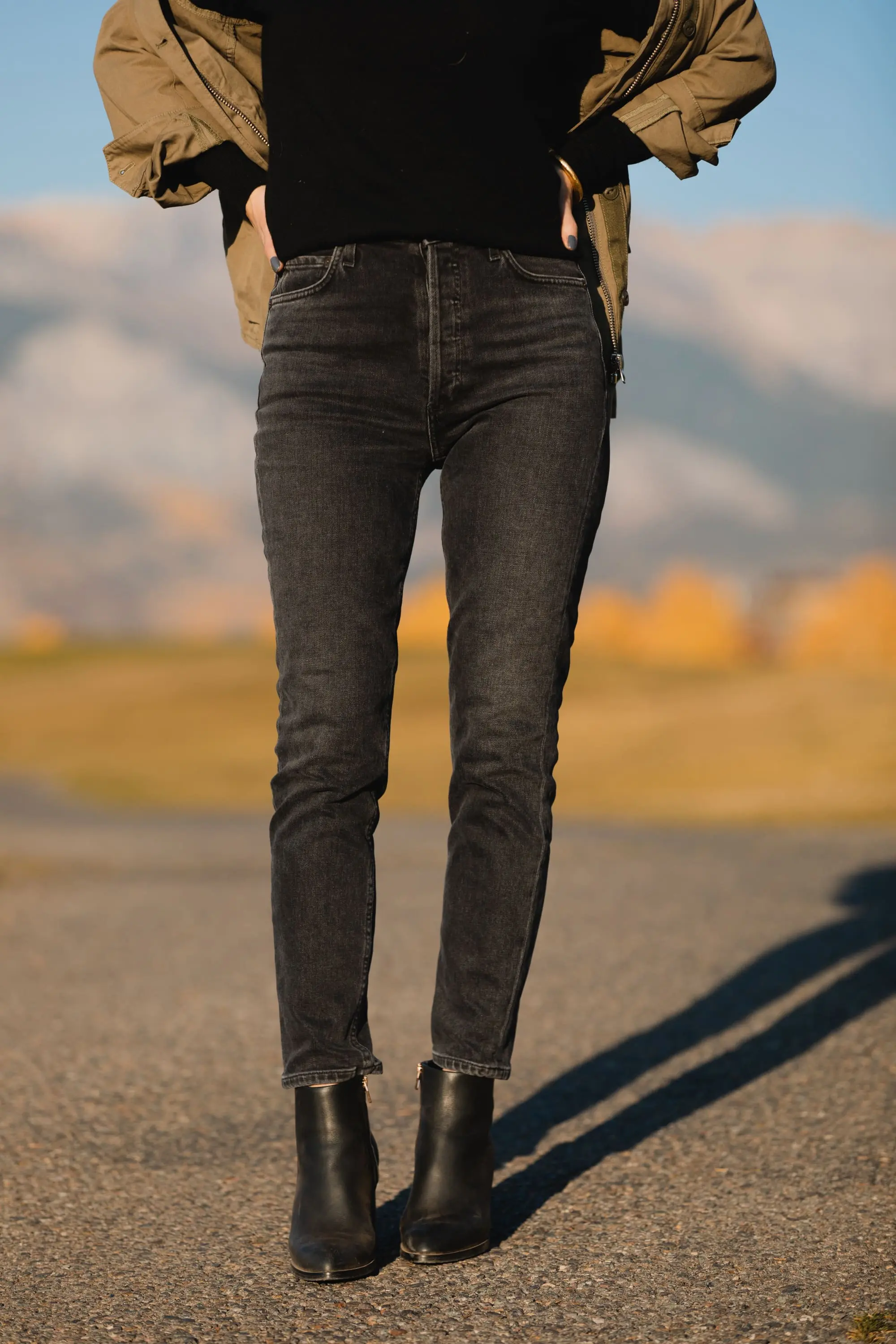 How To Wear A Cargo Jacket, Erin Busbee of Busbee Style wearing a green cargo jacket by rag & bone, black turtleneck puff sleeve cashmere sweater by Aqua, gray wash Nico slim fit jeans by Agolde, QUAY sunglasses, and Alexander Wang cutout booties in Telluride, Colorado