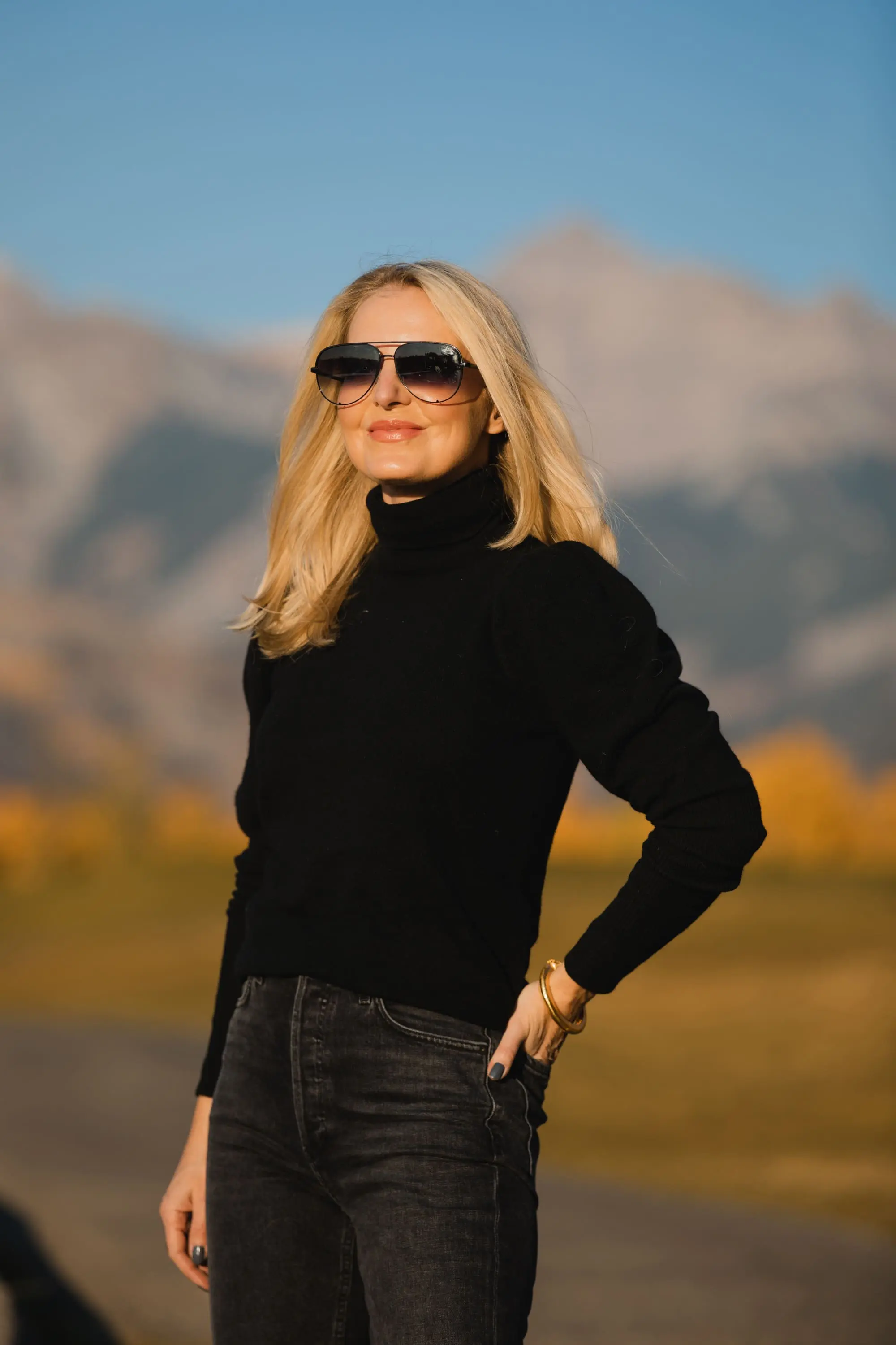 How To Wear A Cargo Jacket, Erin Busbee of Busbee Style wearing a black turtleneck puff sleeve cashmere sweater by Aqua, gray wash Nico slim fit jeans by Agolde, QUAY sunglasses, and Alexander Wang cutout booties in Telluride, Colorado
