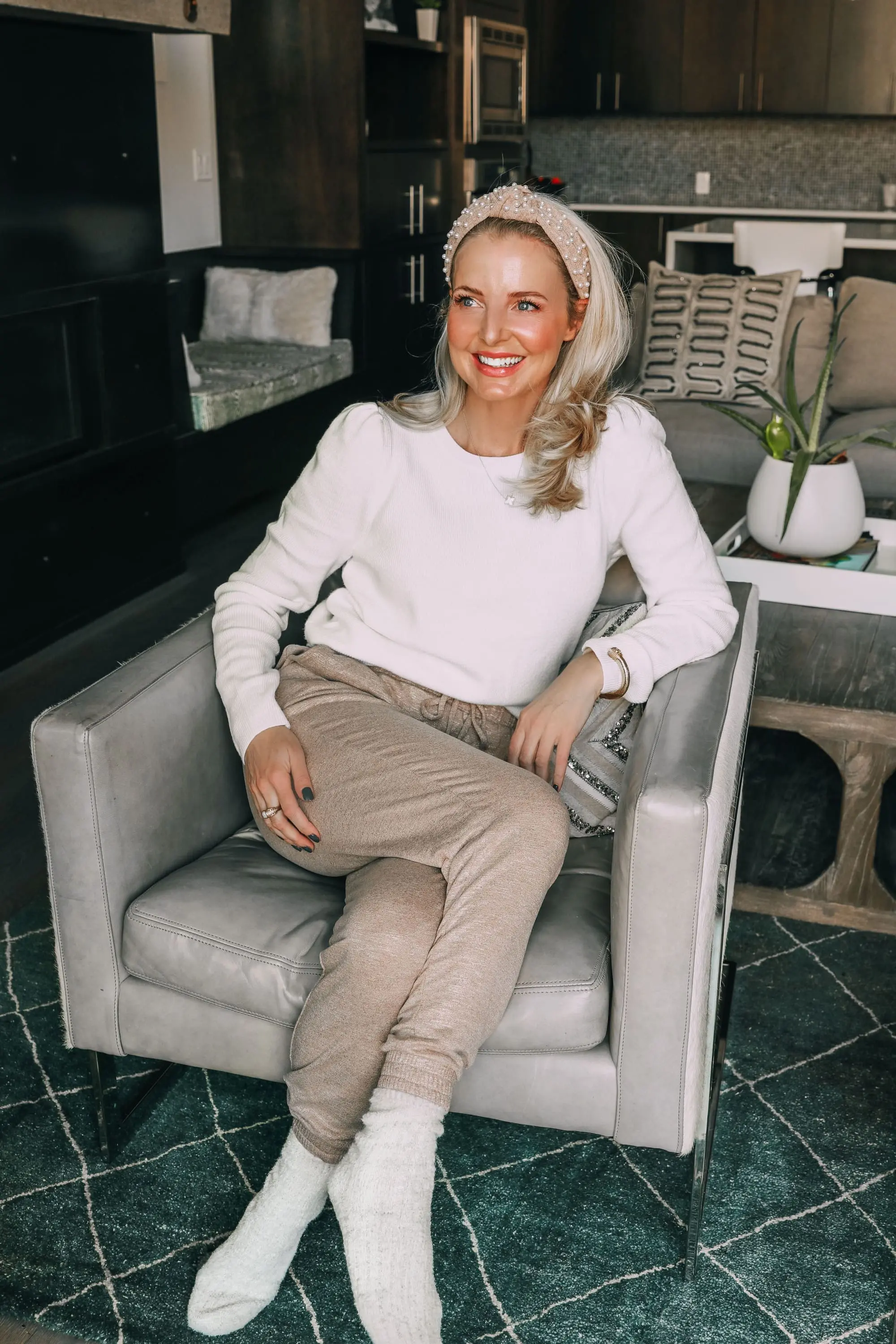 Loungewear over 40, how to look chic and polished fashion over 40 blogger Erin Busbee wearing Express metallic joggers and white ribbed puff shoulder sweater with pearl headband and fuzzy socks