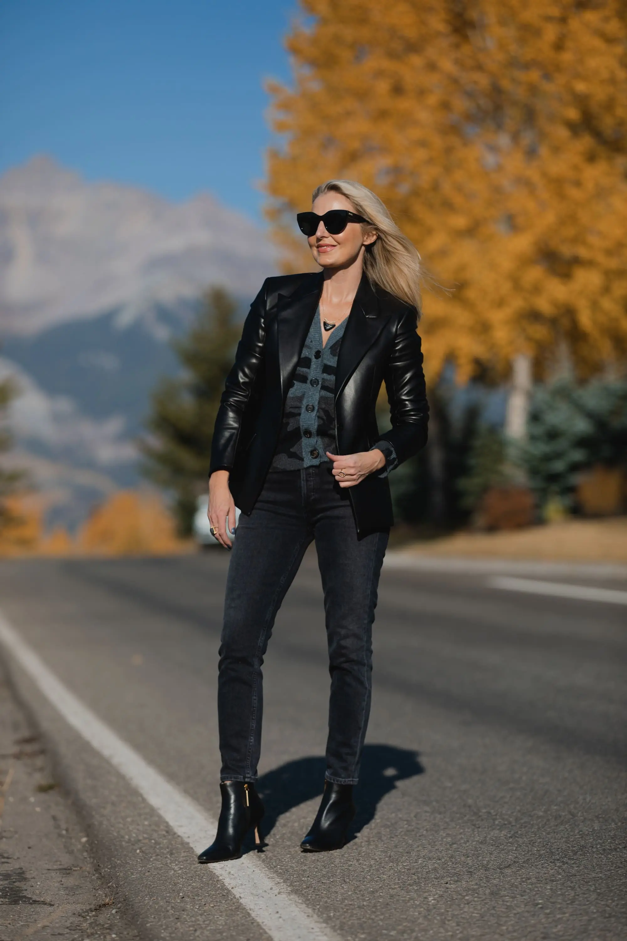 Favorite Fall Jackets, Erin Busbee of Busbee Style holding a black faux leather blazer by Theory and wearing dark gray wash Agolde Nico jeans, black Louise et Cie booties, and Rails camo cardigan sweater in Telluride, Colorado