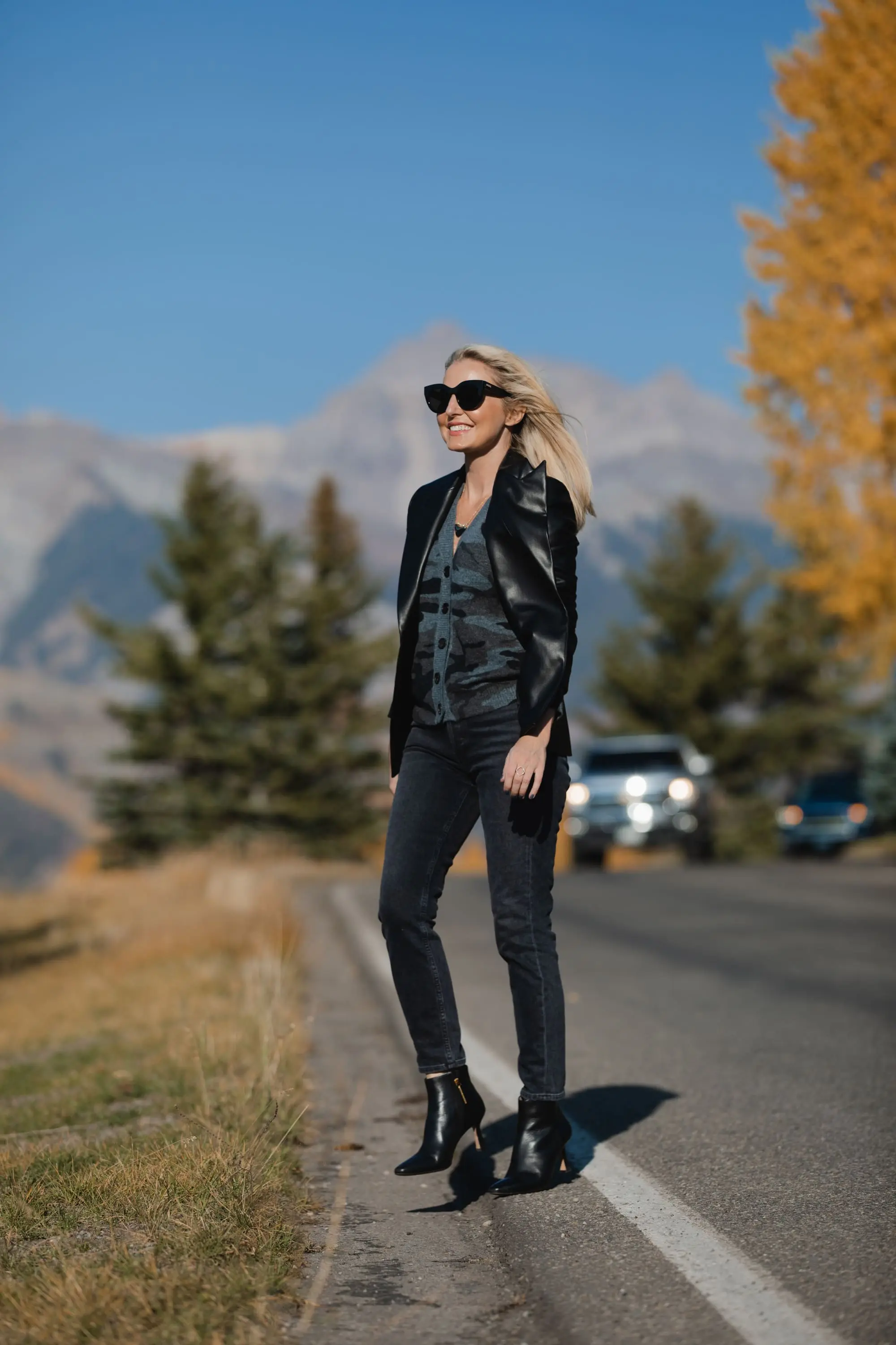 Favorite Fall Jackets, Erin Busbee of Busbee Style holding a black faux leather blazer by Theory and wearing dark gray wash Agolde Nico jeans, black Louise et Cie booties, and Rails camo cardigan sweater in Telluride, Colorado