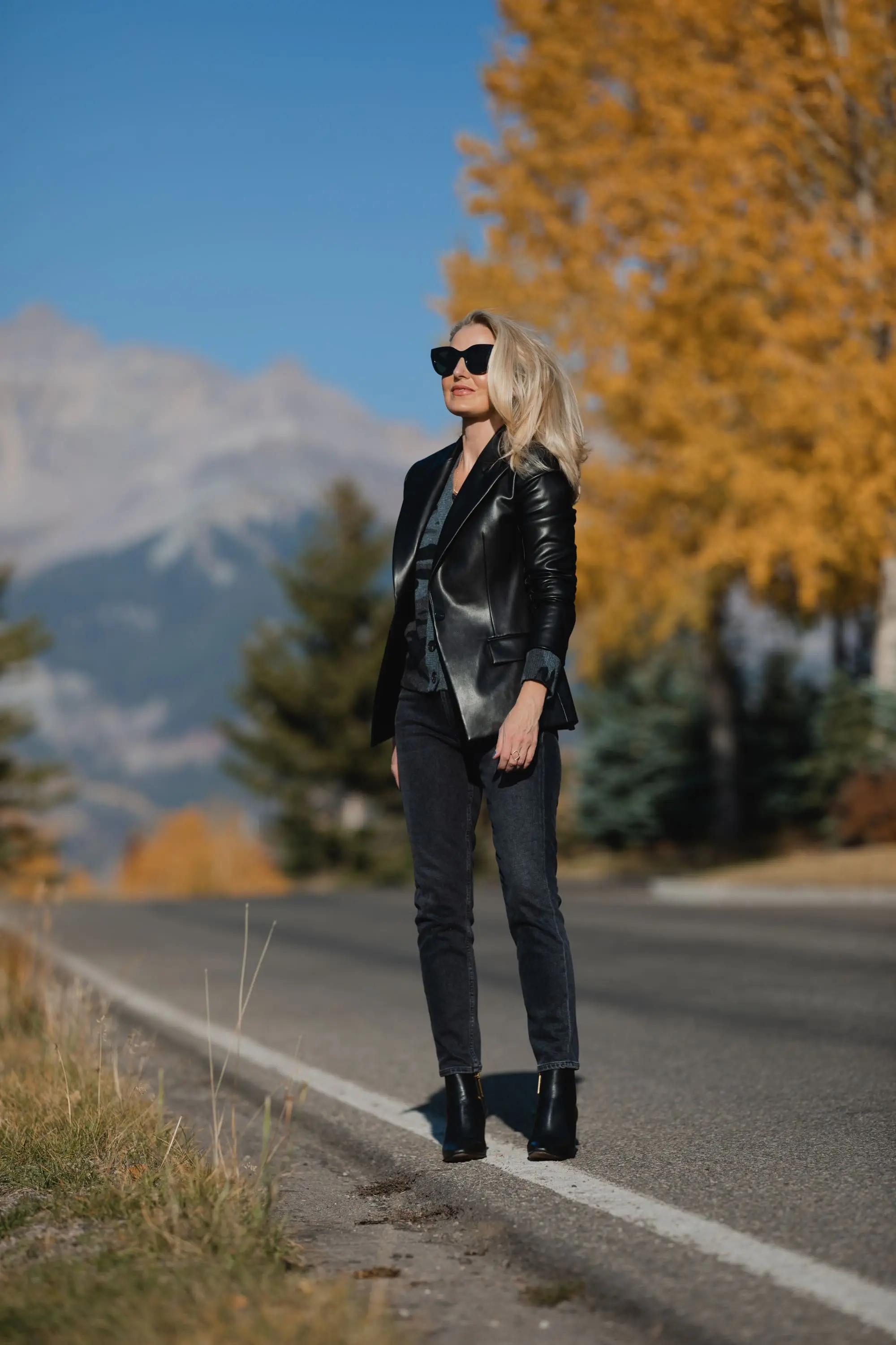Favorite Fall Jackets, Erin Busbee of Busbee Style holding a black faux leather blazer by Theory and wearing dark gray wash Agolde Nico jeans, black Louise et Cie booties, and Rails camo cardigan sweater in Telluride, Colorado
