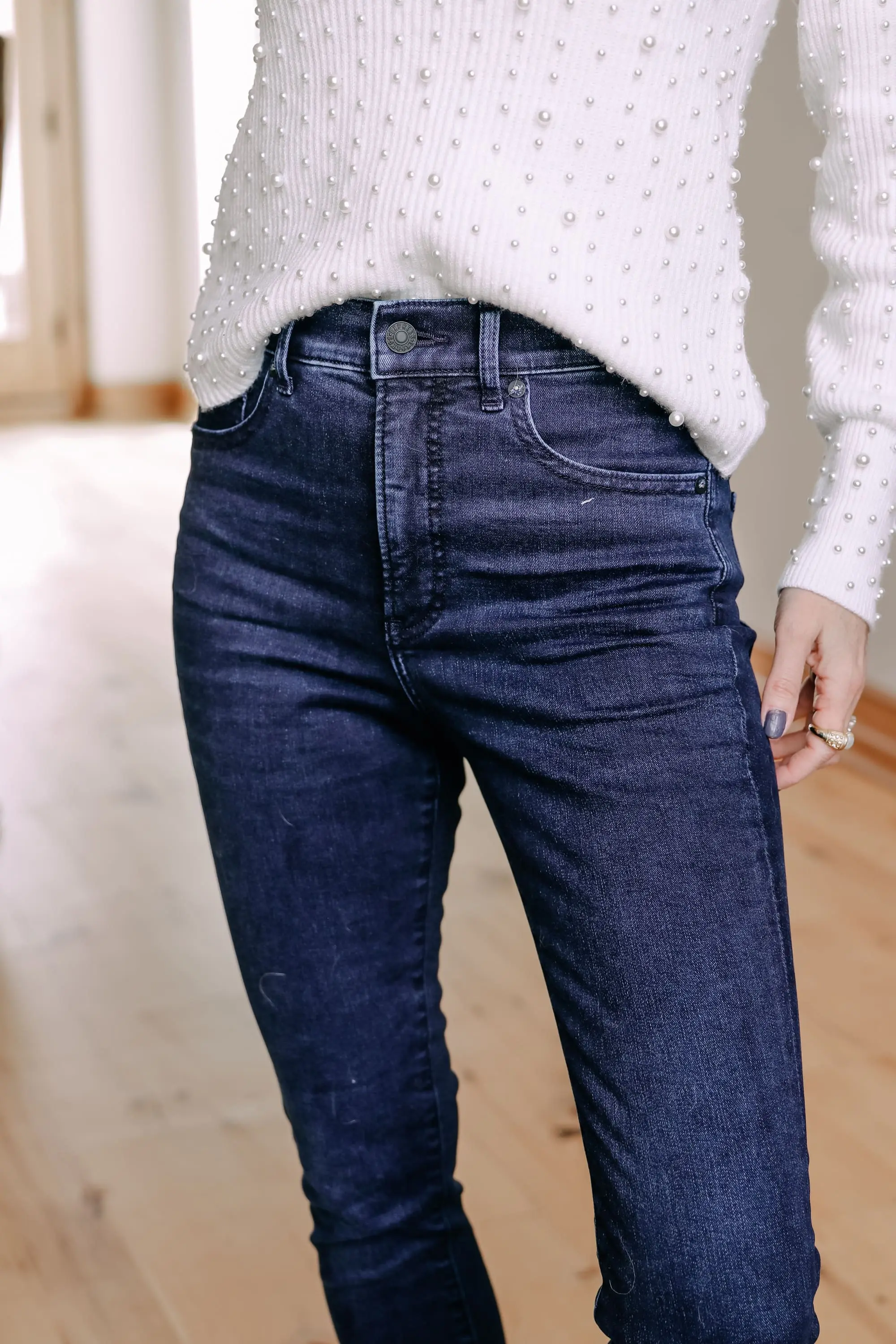Black Friday Doorbuster, Erin Busbee of Busbee Style wearing a pearl embellished white sweater, raw step hem jeans, and cozy socks from Express in Telluride, Colorado