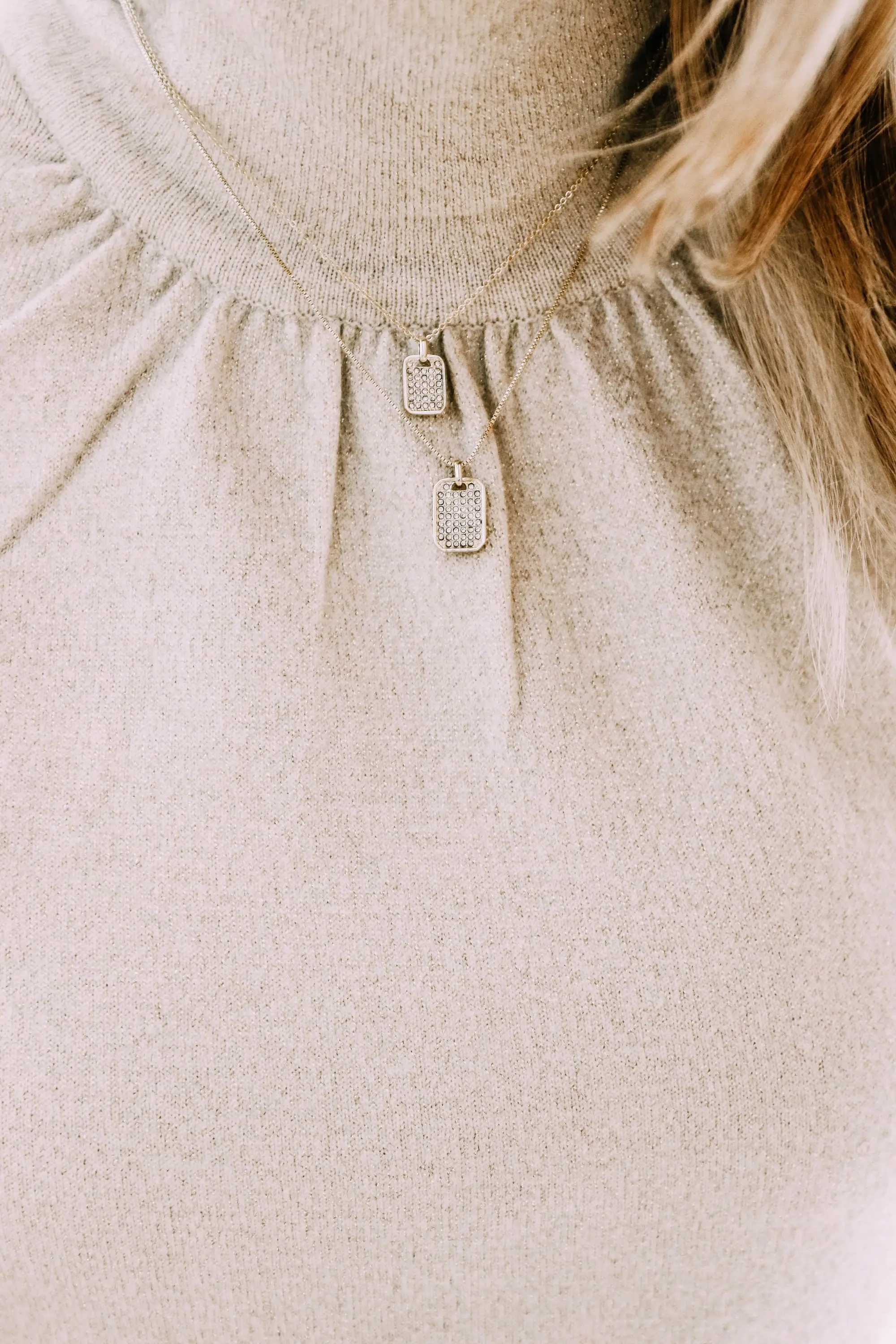 Black Friday Doorbuster, Erin Busbee of Busbee Style wearing a metallic blouson sleeve turtleneck sweater, raw step hem jeans, pave layered dog tag necklace, and cozy socks from Express in Telluride, Colorado